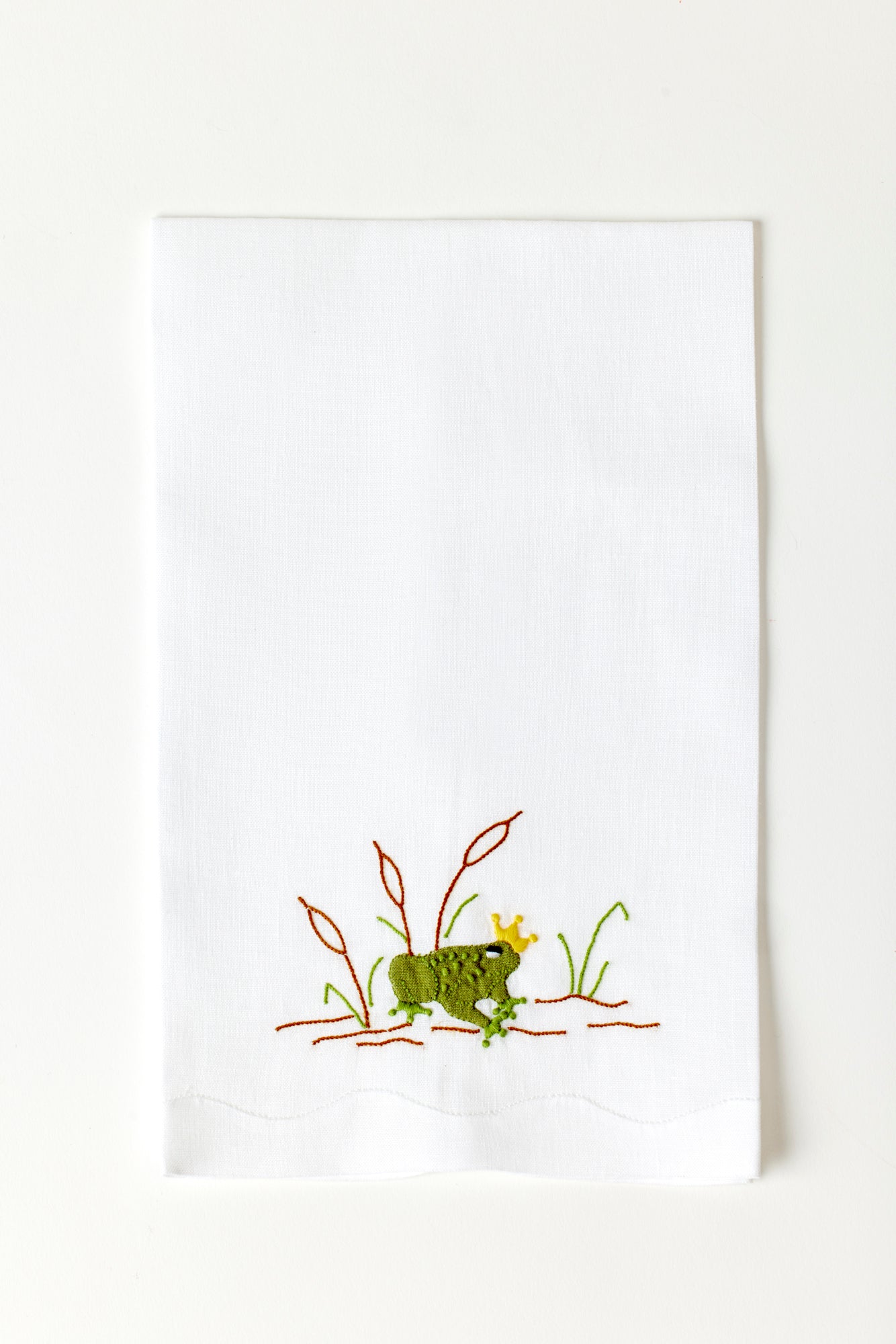 Frog prince guest towel made with hand embroidery and appliqué in Madeira, Portugal.
