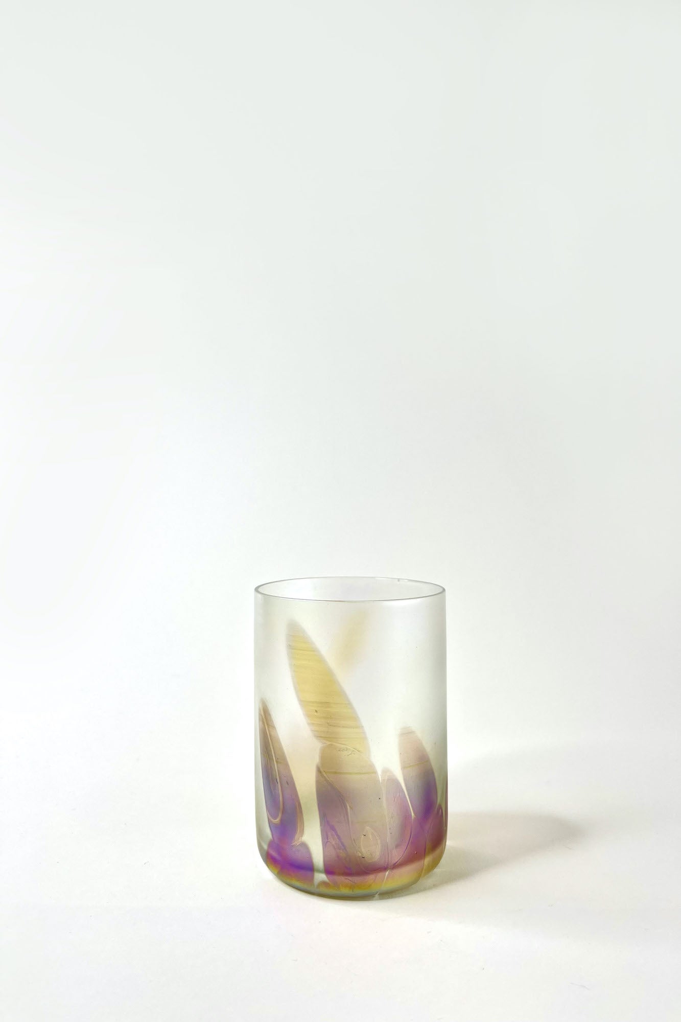 Medium iridescent glass tumblers with purple and golden shapes.