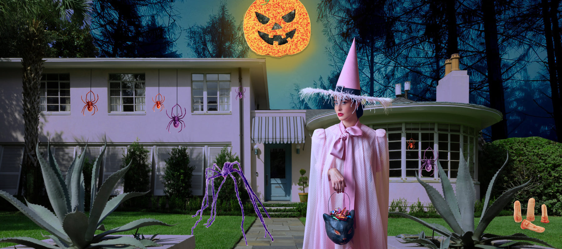 Woman wearing pink witch hat in front of spooky home and pumpkin cookie moon