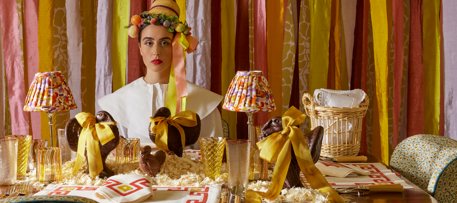 Woman wearing cornucopia hat at colorful table with chocolate turkeys