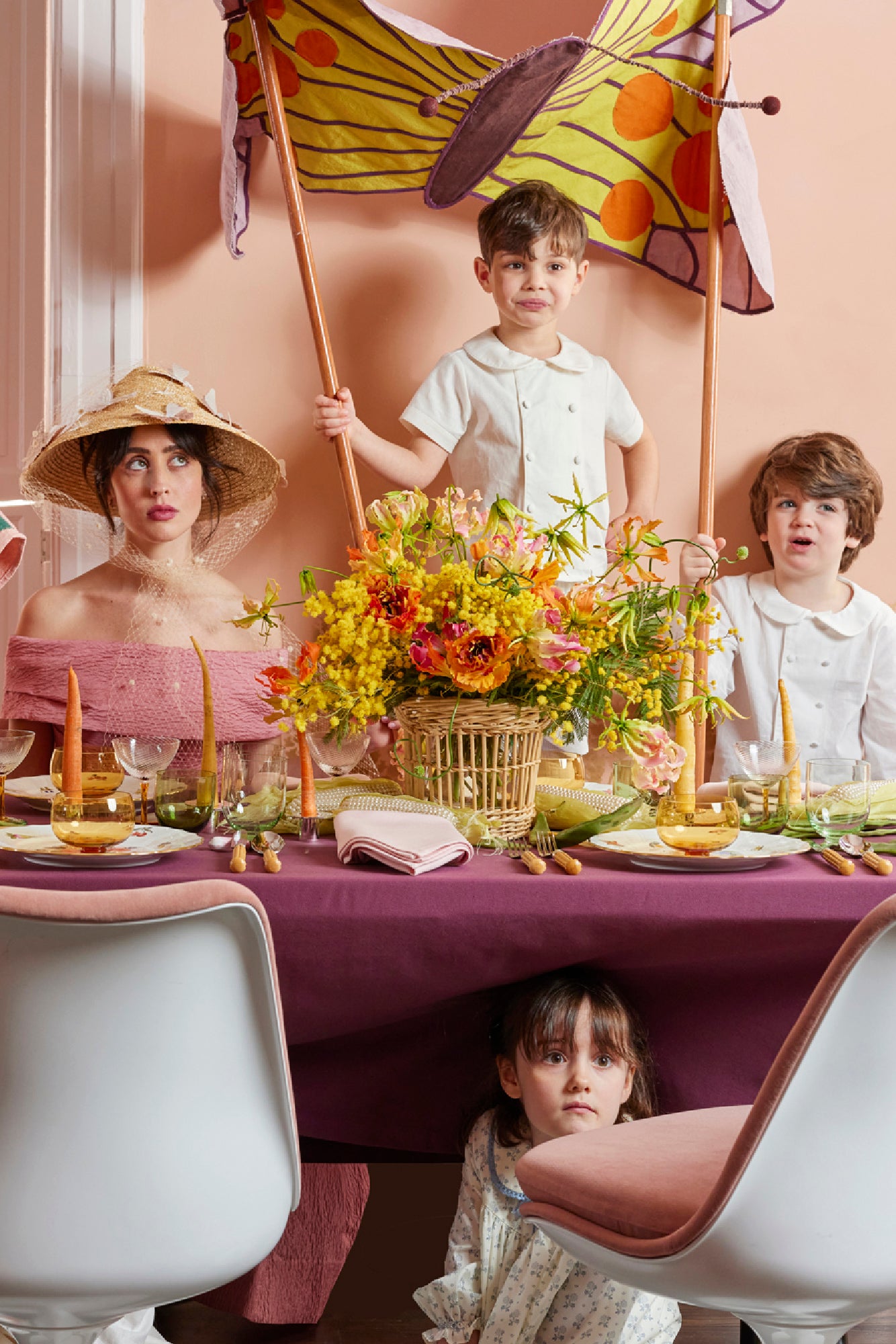 Lively Spring table scape with color block tablecloth in eggplant, pearl corn, bamboo flatware, carrot taper candles, Nason Moretti coupe glass and 3 piece bowl, wine glass and water glass set.