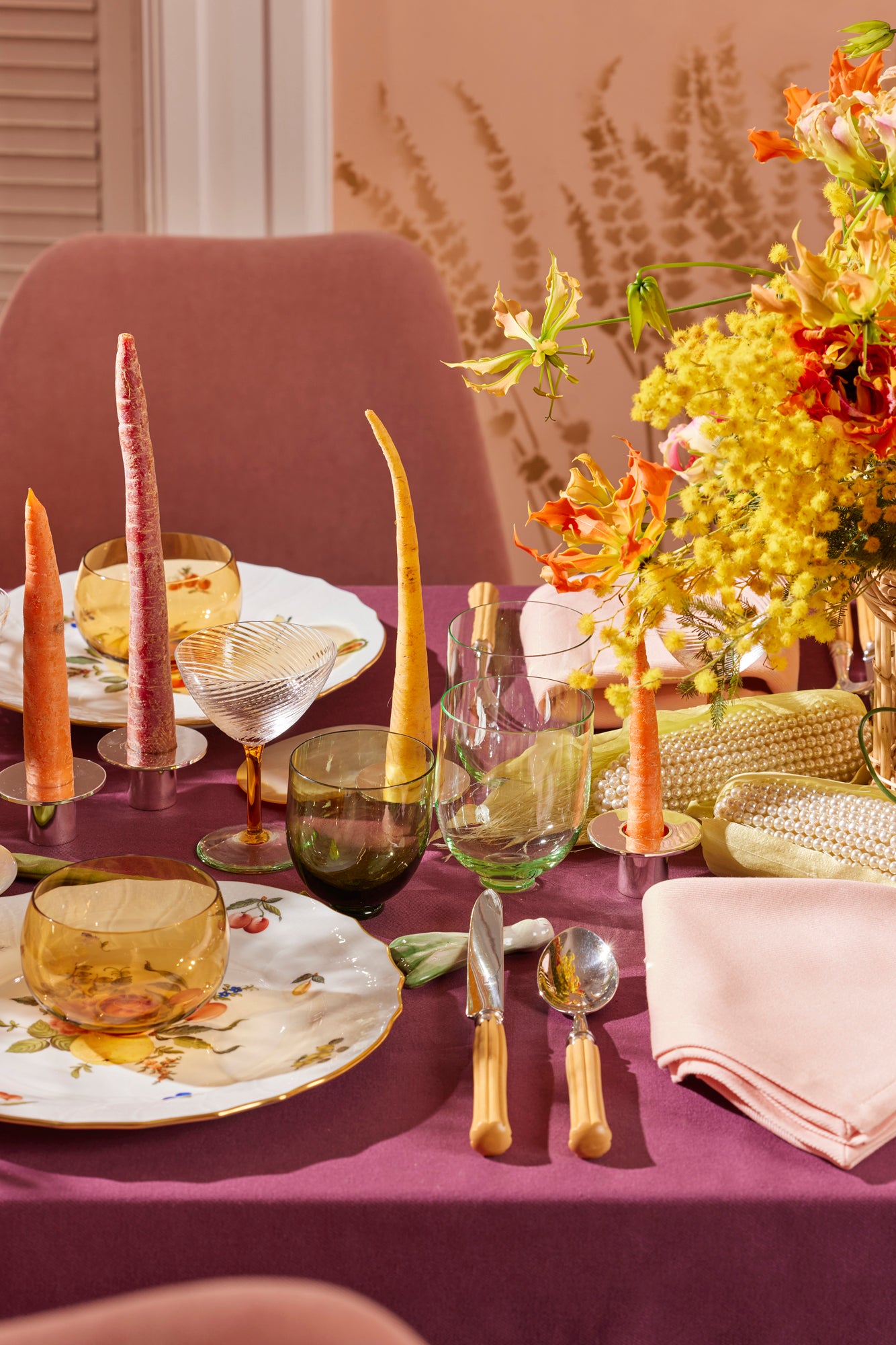 Beautiful spring table scape with pearl corns, color block tablecloth and coupe glasses.