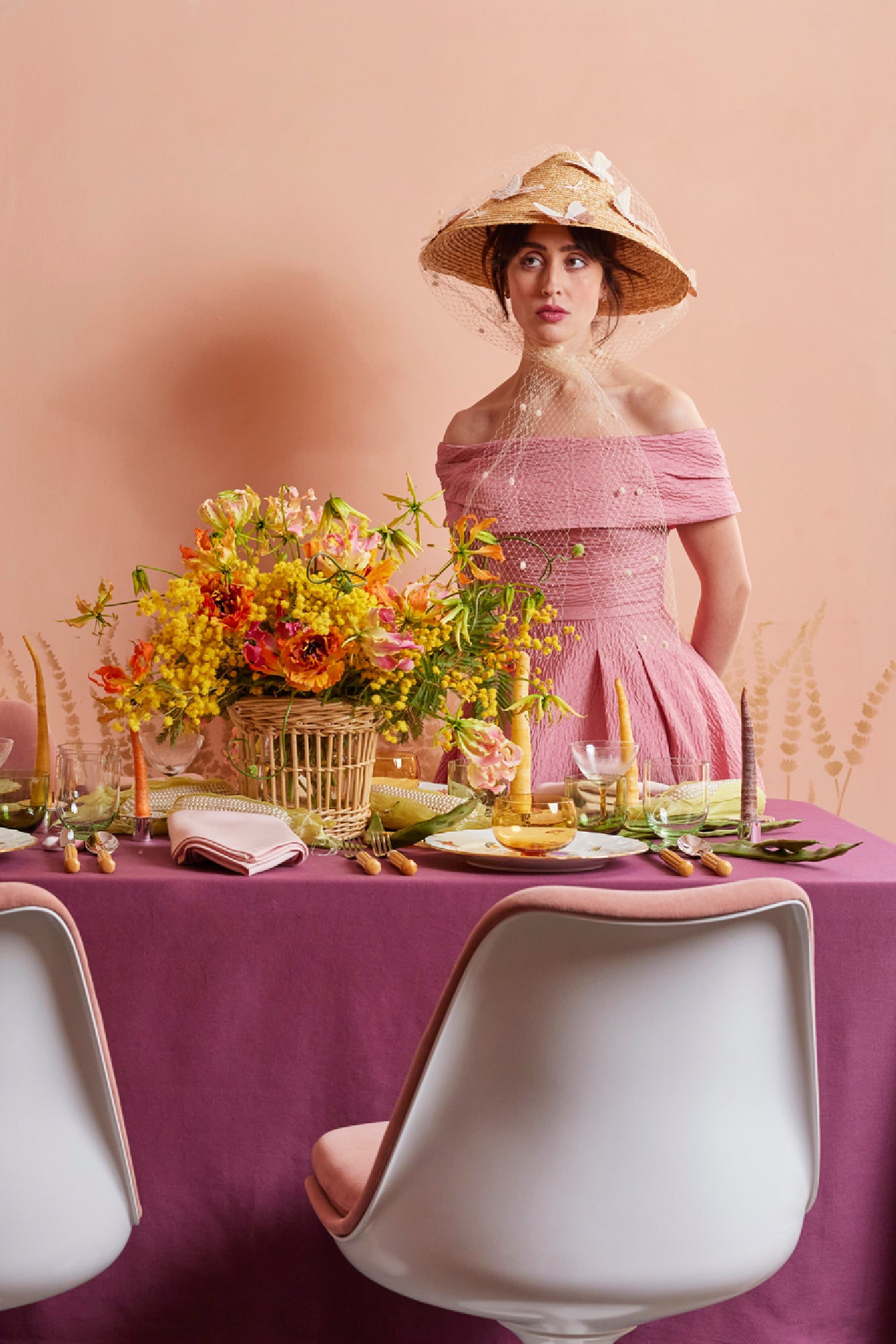 Lively Spring table scape with color block tablecloth in eggplant, bamboo flatware, carrot taper candles, Nason Moretti coupe glass and 3 piece bowl, wine glass and water glass set.