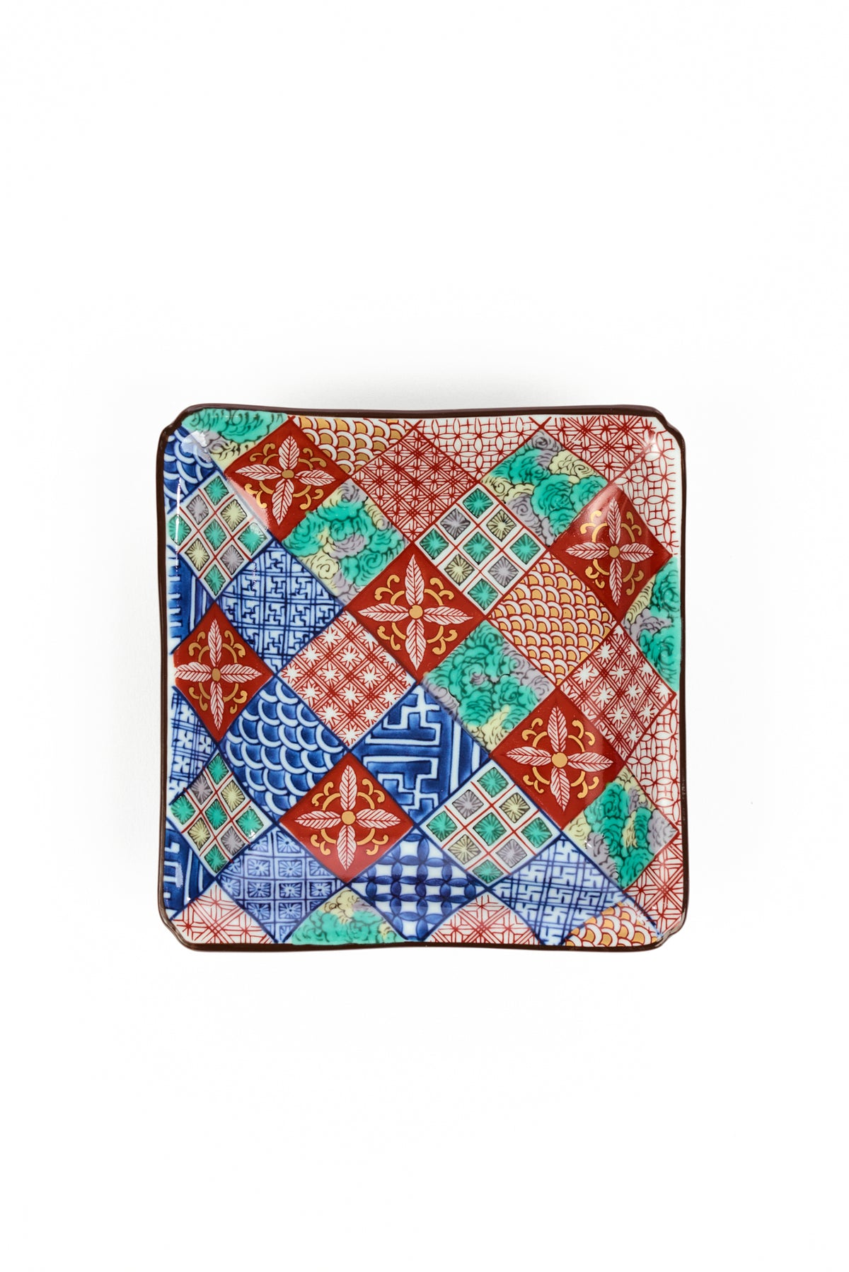 A square ceramic salad plate with a colorful patchwork tile pattern featuring red, blue, green, and orange geometric designs, set against a plain white background.