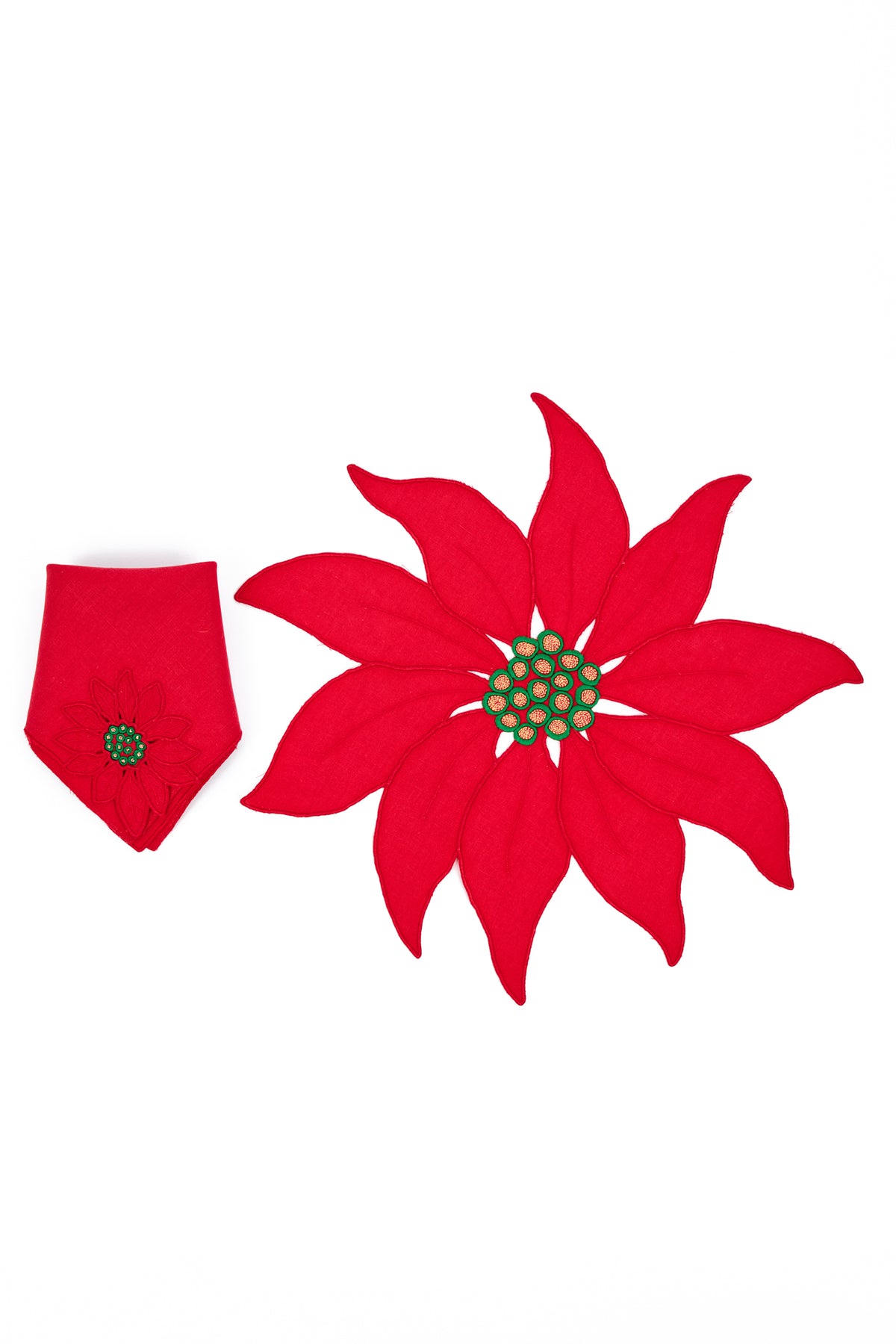 A poinsettia-shaped fabric napkin and place mats  in red, arranged on a plain white background.