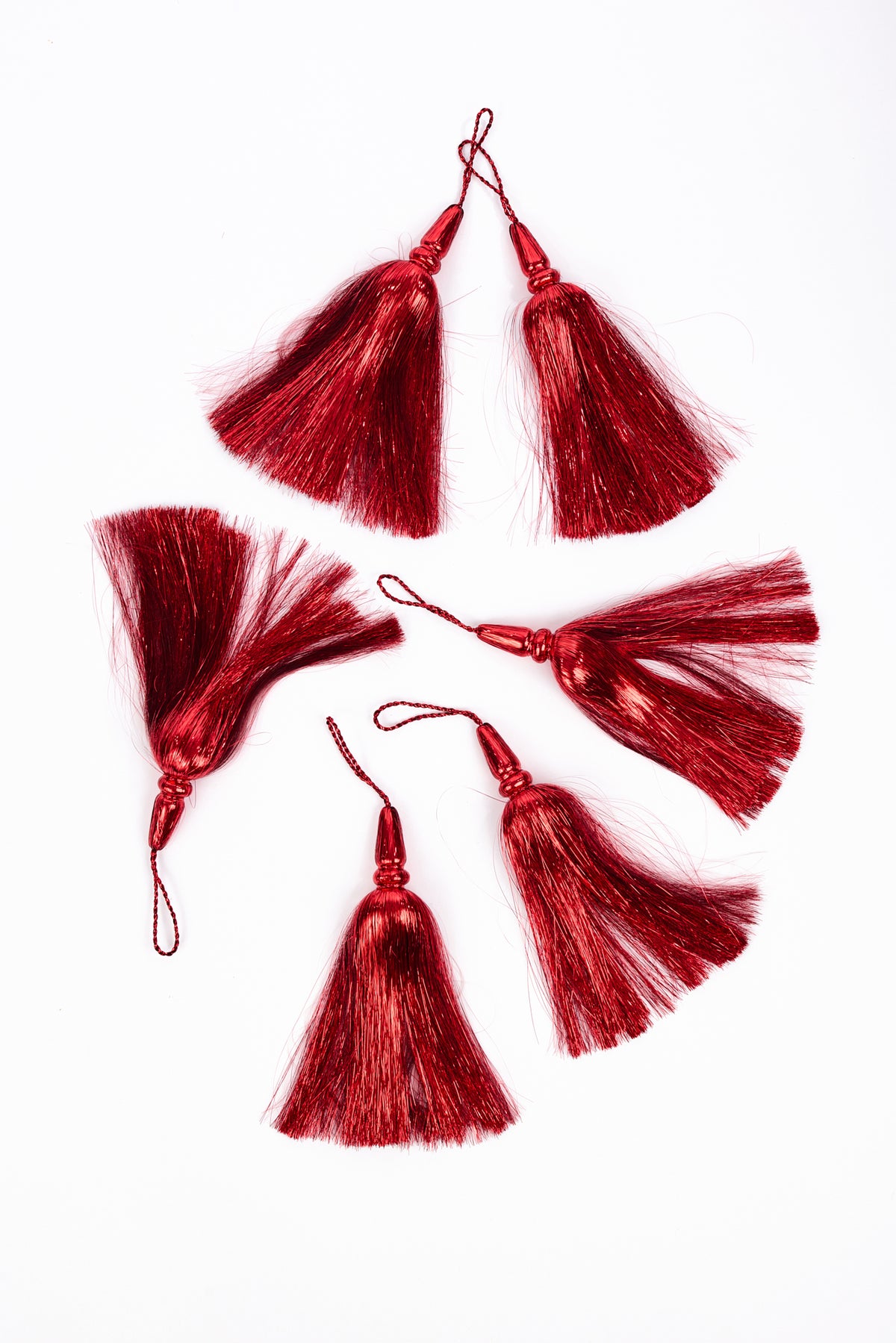 6 red silk tassels with hanging loops, arranged on a plain white background.