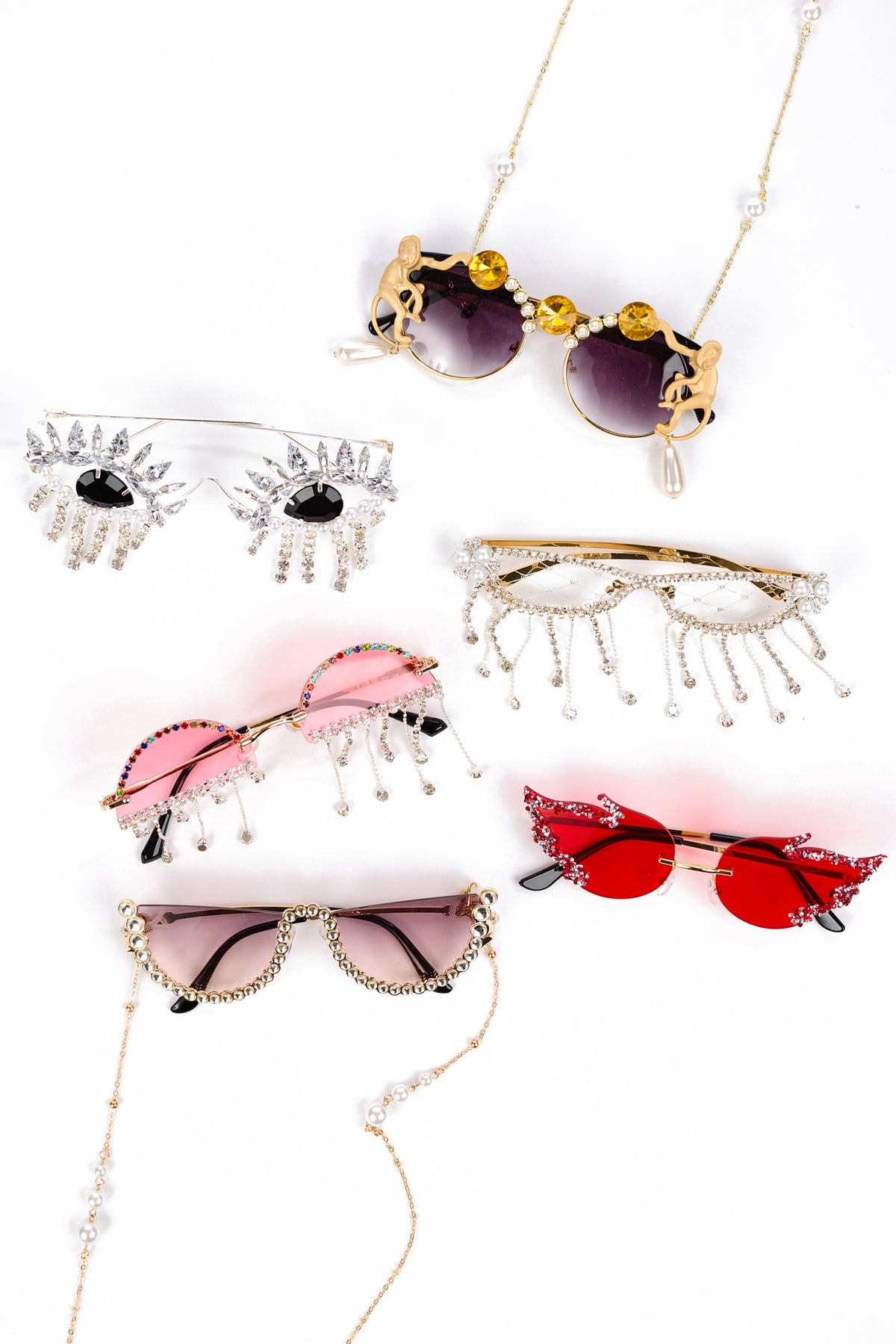 Six pairs of novelty sunglasses with rhinestone eye details and dangling pearl chains, displayed on a clean white background.