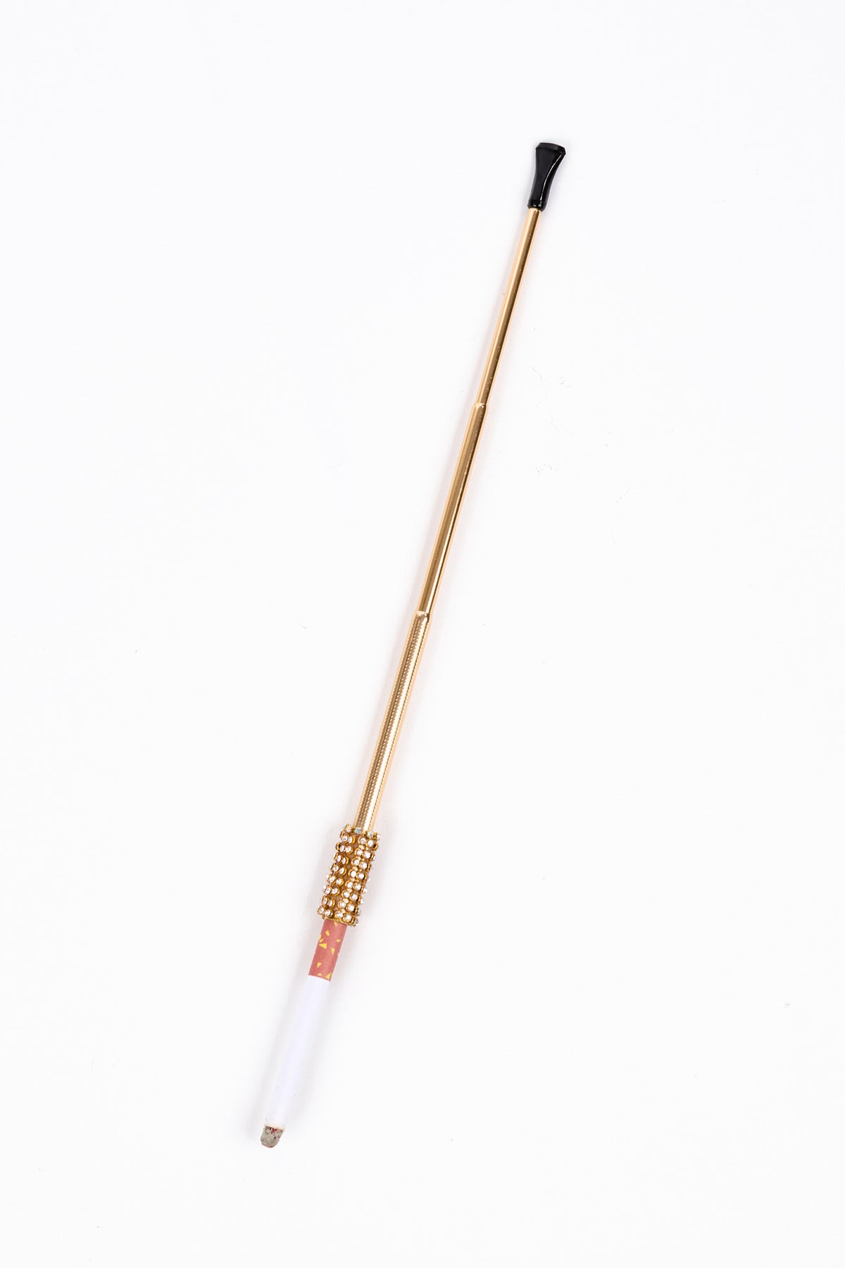 Long, bloc-tipped, telescoping gold cigarette holder with a bedazzled rhinestone collar, holding a partially burnt cigarette.