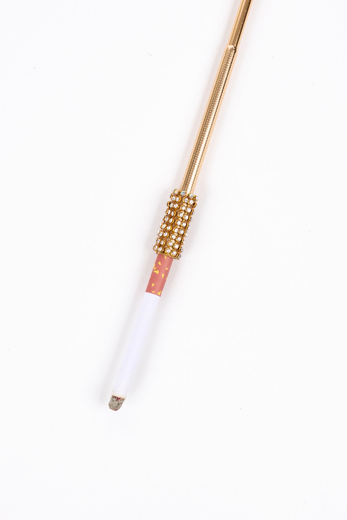 Gold Cigarette Holder with a bedazzled rhinestone collar, holding a partially burnt cigarette.