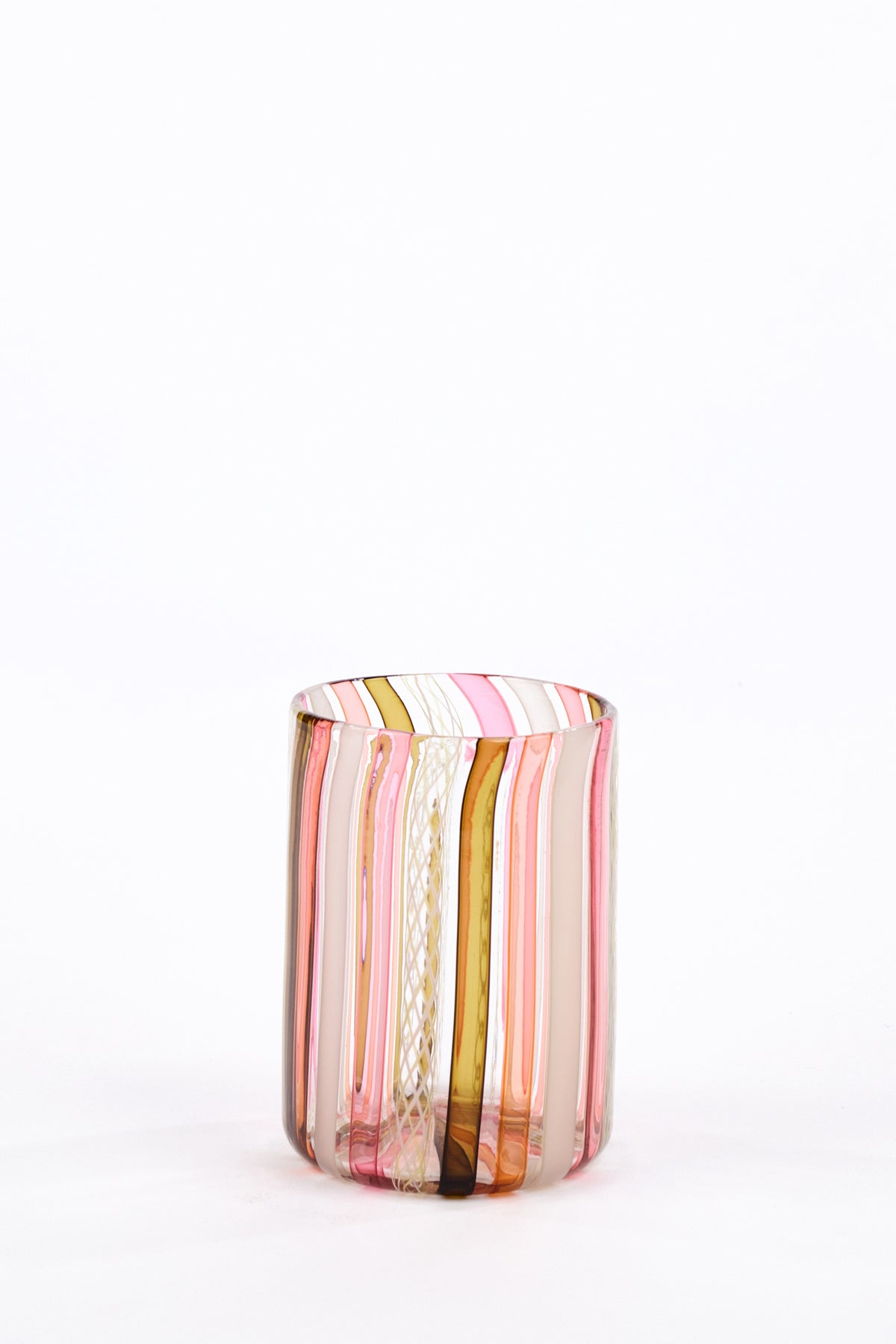 A small cylindrical glass tumbler with vertical hand-blown stripes in pink, white, and dark olive green, set against a seamless white background.
