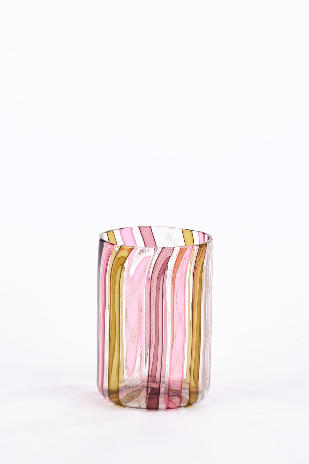 A hand-blown glass tumbler featuring vertical wavy stripes in pink, olive green on a clear glass base, set against a plain white background.