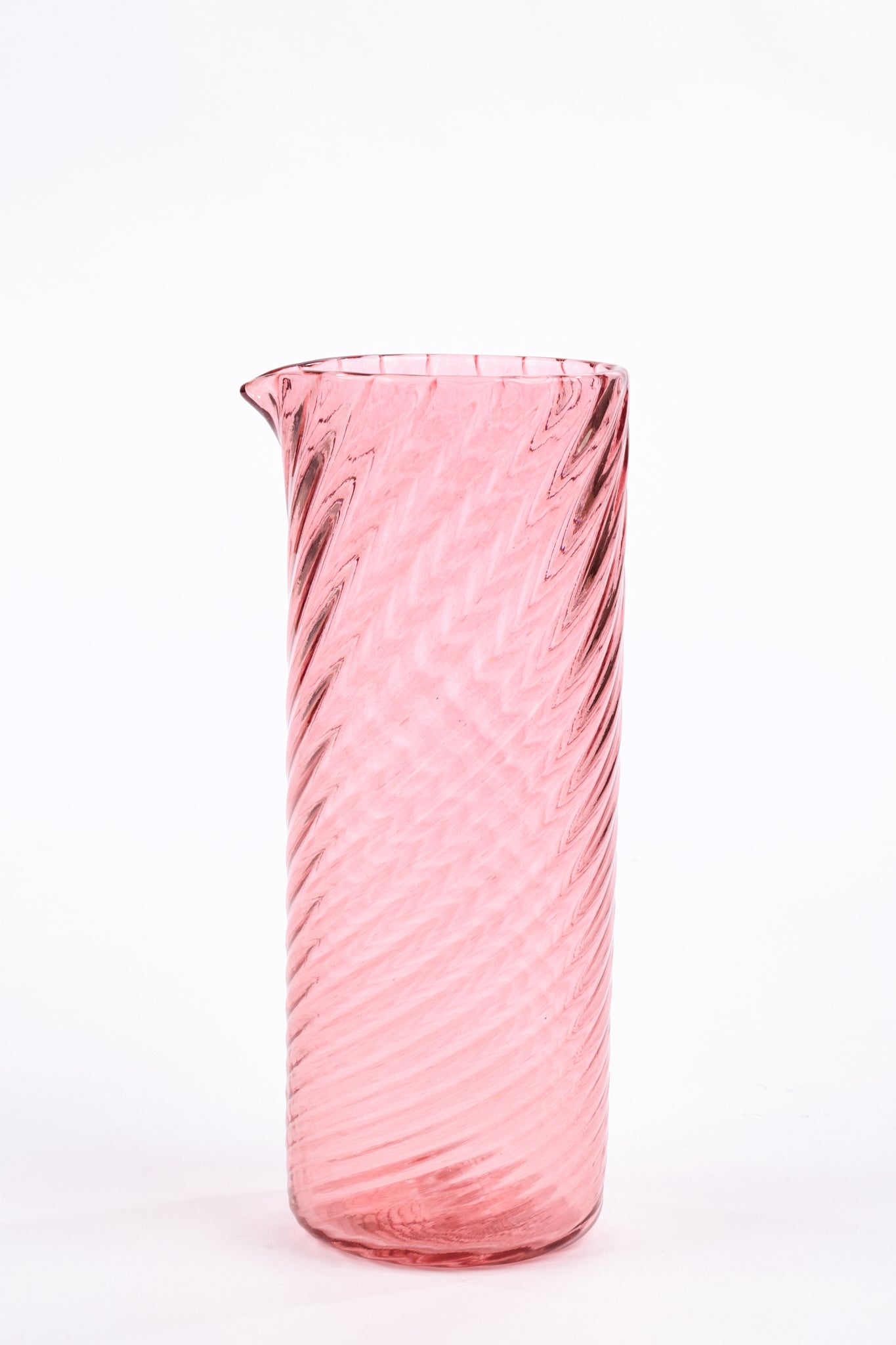 A tall, cylindrical pink glass pitcher with a twisted spiral pattern and a small pouring spout, set against a plain white background.