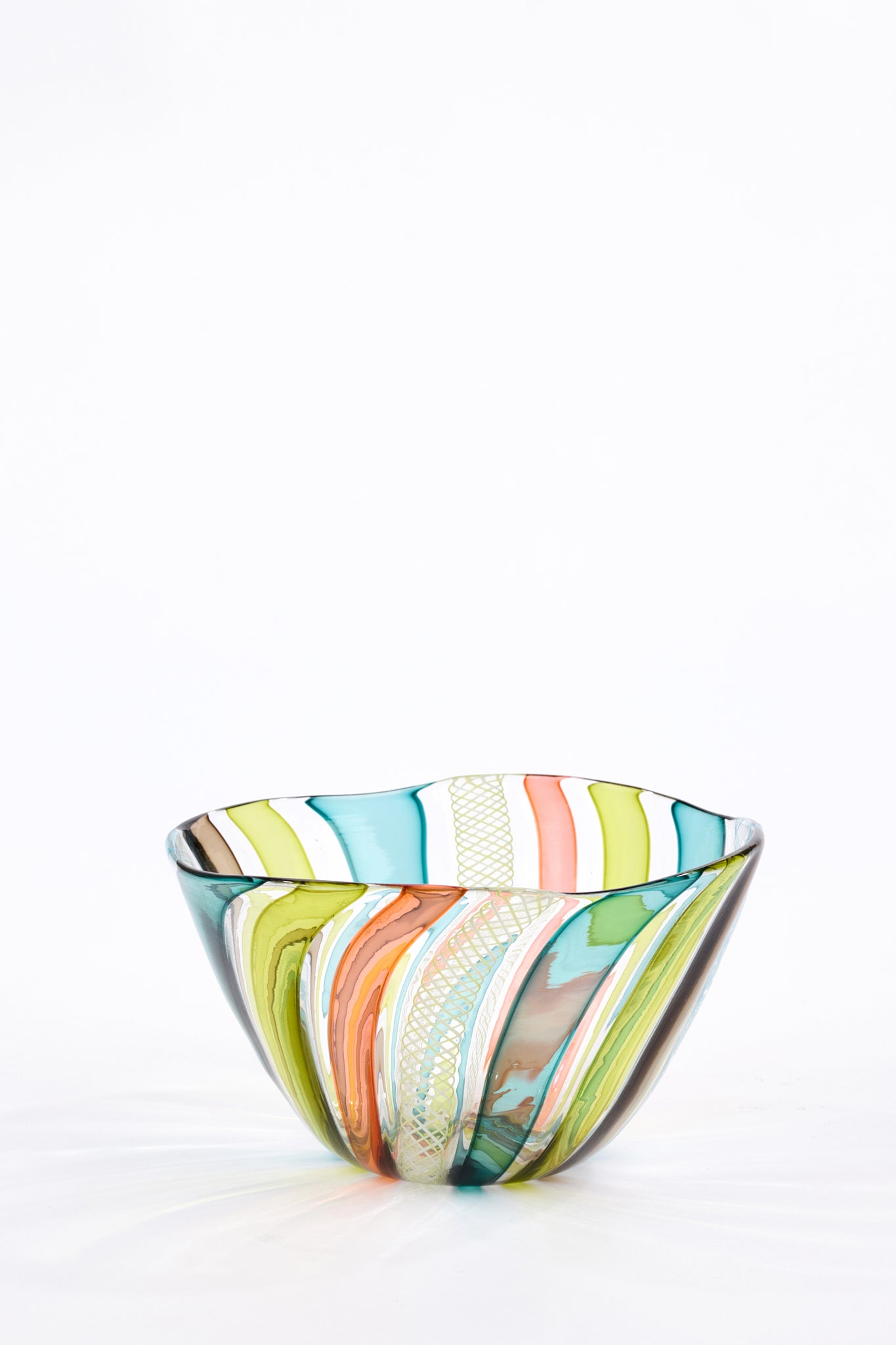 A handcrafted glass bowl with a vibrant, multicolored swirl pattern of green, yellow, orange, pink, blue, and white, set against a clean white background.