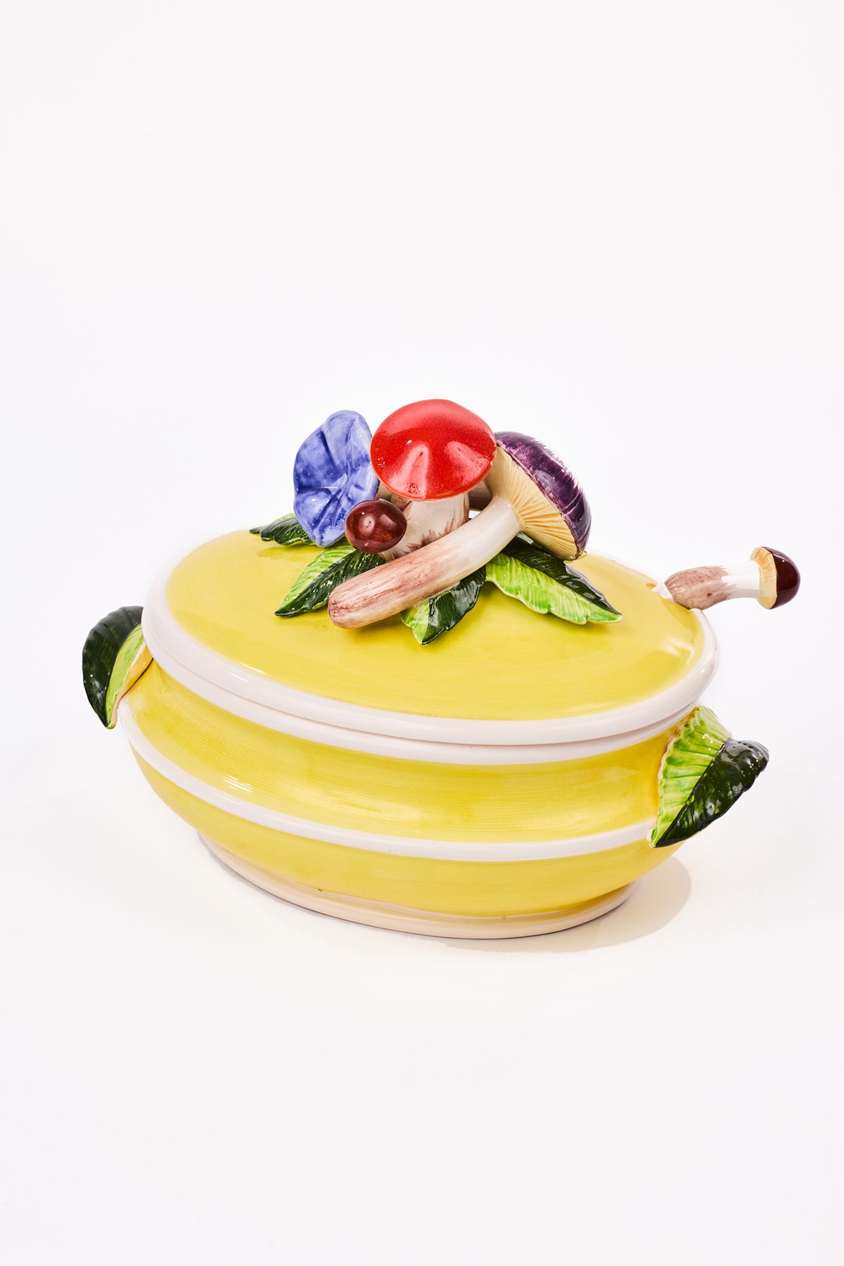 A yellow ceramic lidded container with sculpted mushroom and leaf details on the lid, photographed on a clean white background.