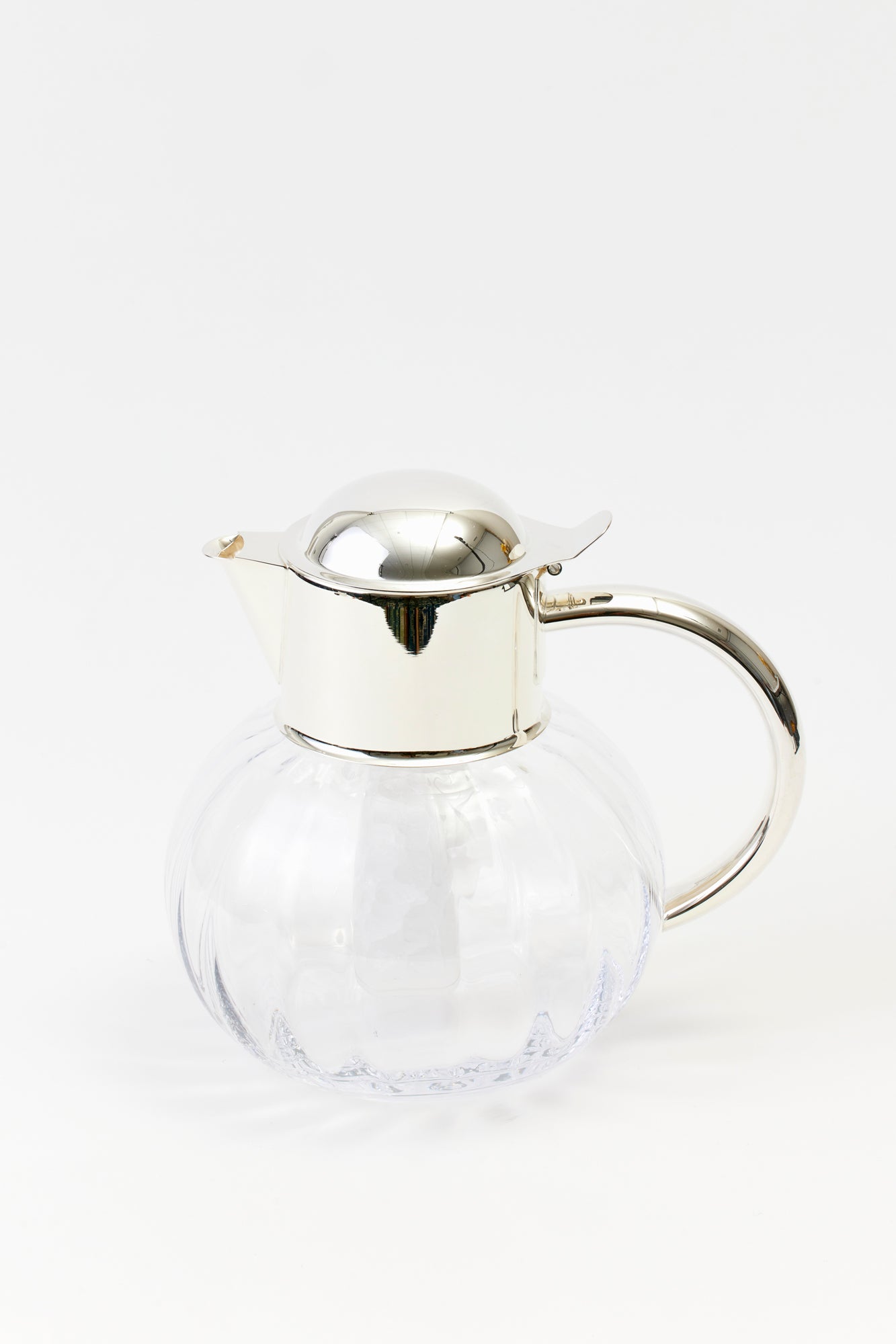 Ice beverage pitcher. Silver-plated top with a crystal body.