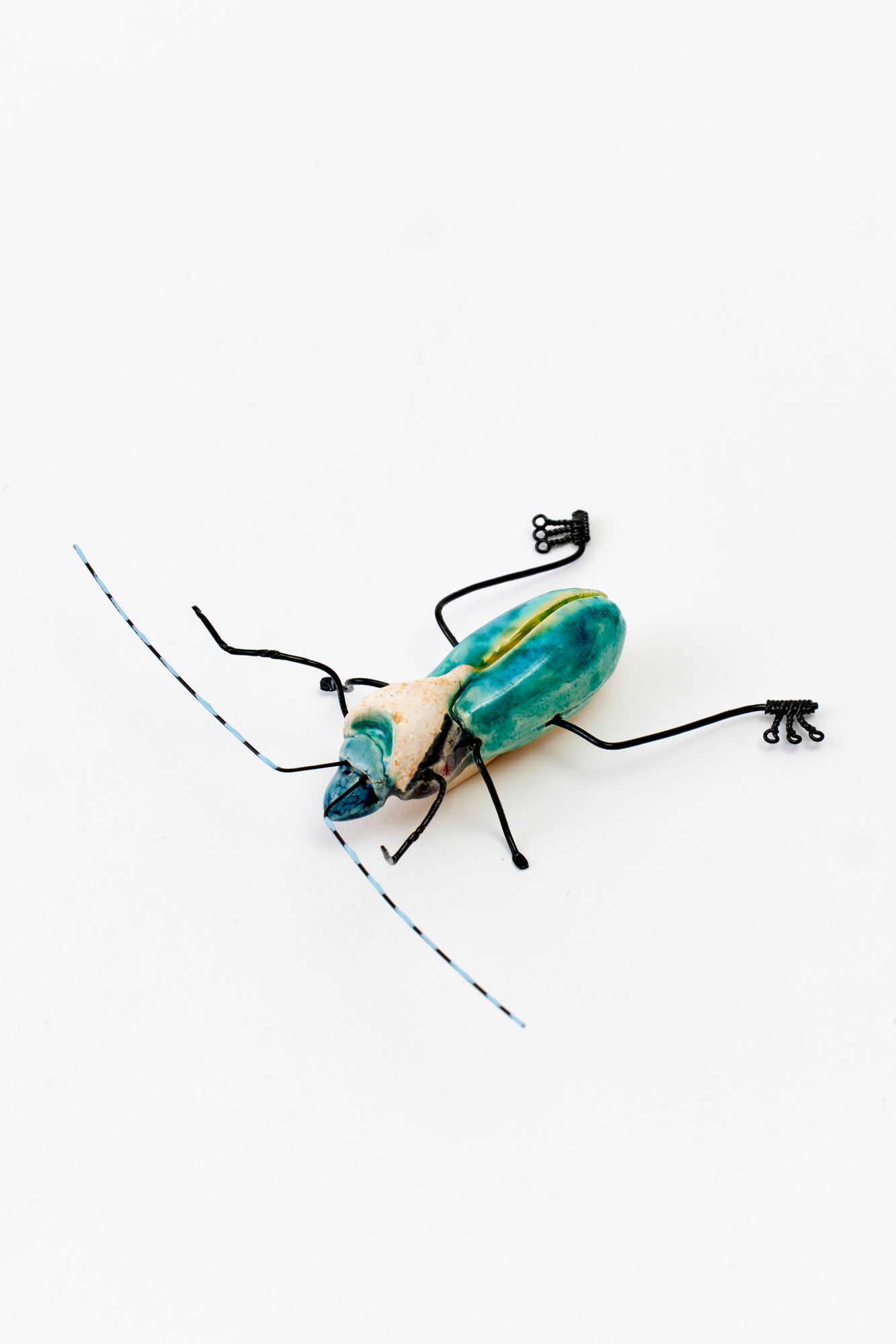 Handmade ceramic insects in various shapes, glazes, and guises.