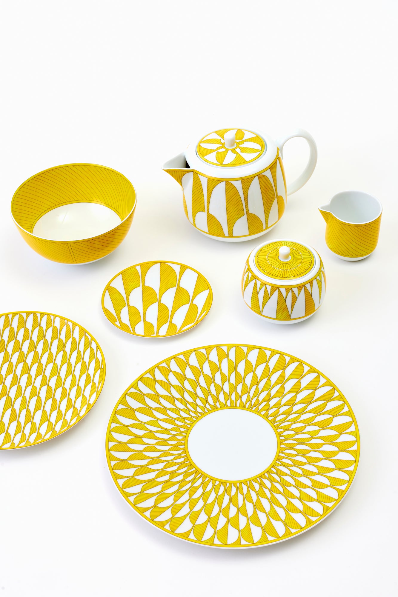 This architectural design by Arielle de Brichambaut for Hermès is intensely ablaze, its graphic forms radiating with warmth. The subtle variation in shades of yellow and the cross-hatched contours give depth to this ode to summer. Convivial, carefree, and even more beautiful in person - just like you. Fine porcelain. Made in France.