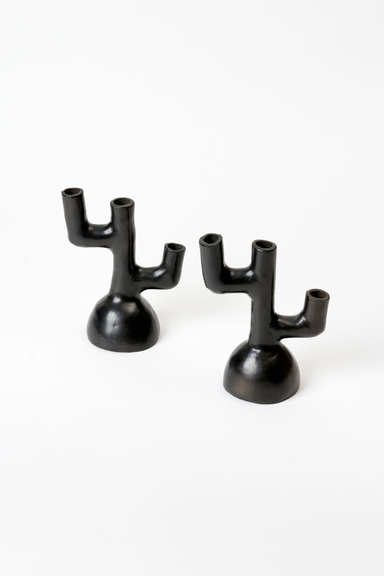 These candlesticks hail from Oaxaca, Mexico. They are made of "barro negro" or "black clay”.