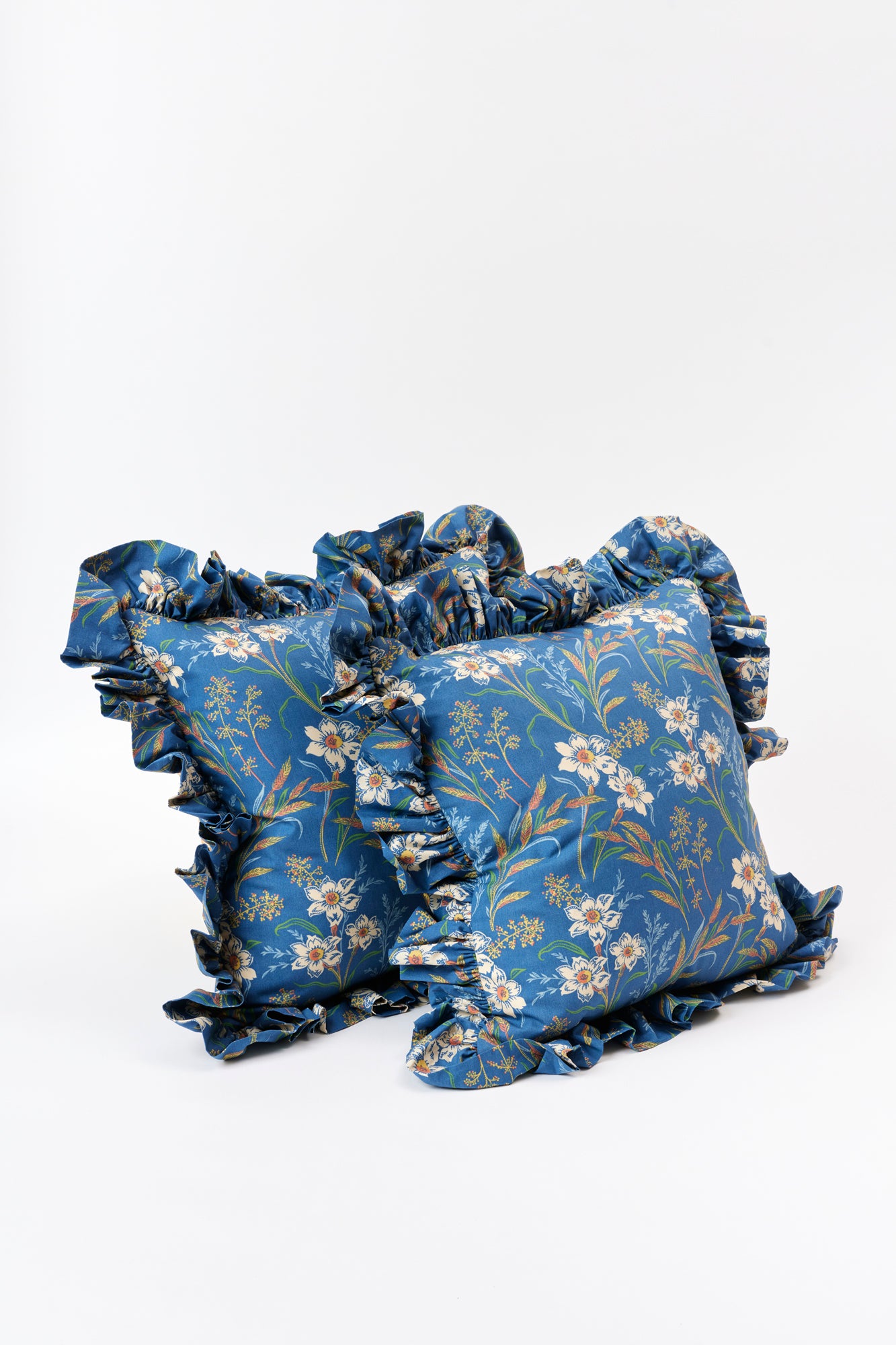 Pair of blue pillows with ruffles.