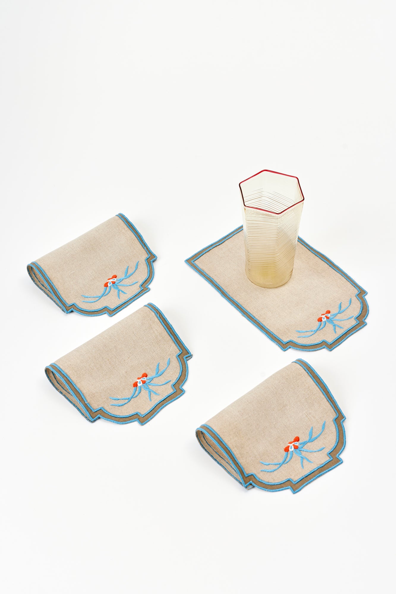 Antique set of arched cocktail napkins with blue trim.