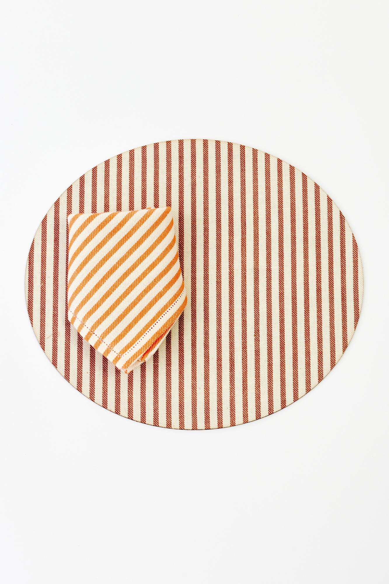 Round placemat with chocolate and cream vertical stripes, adding a classic and elegant touch to any table setting.