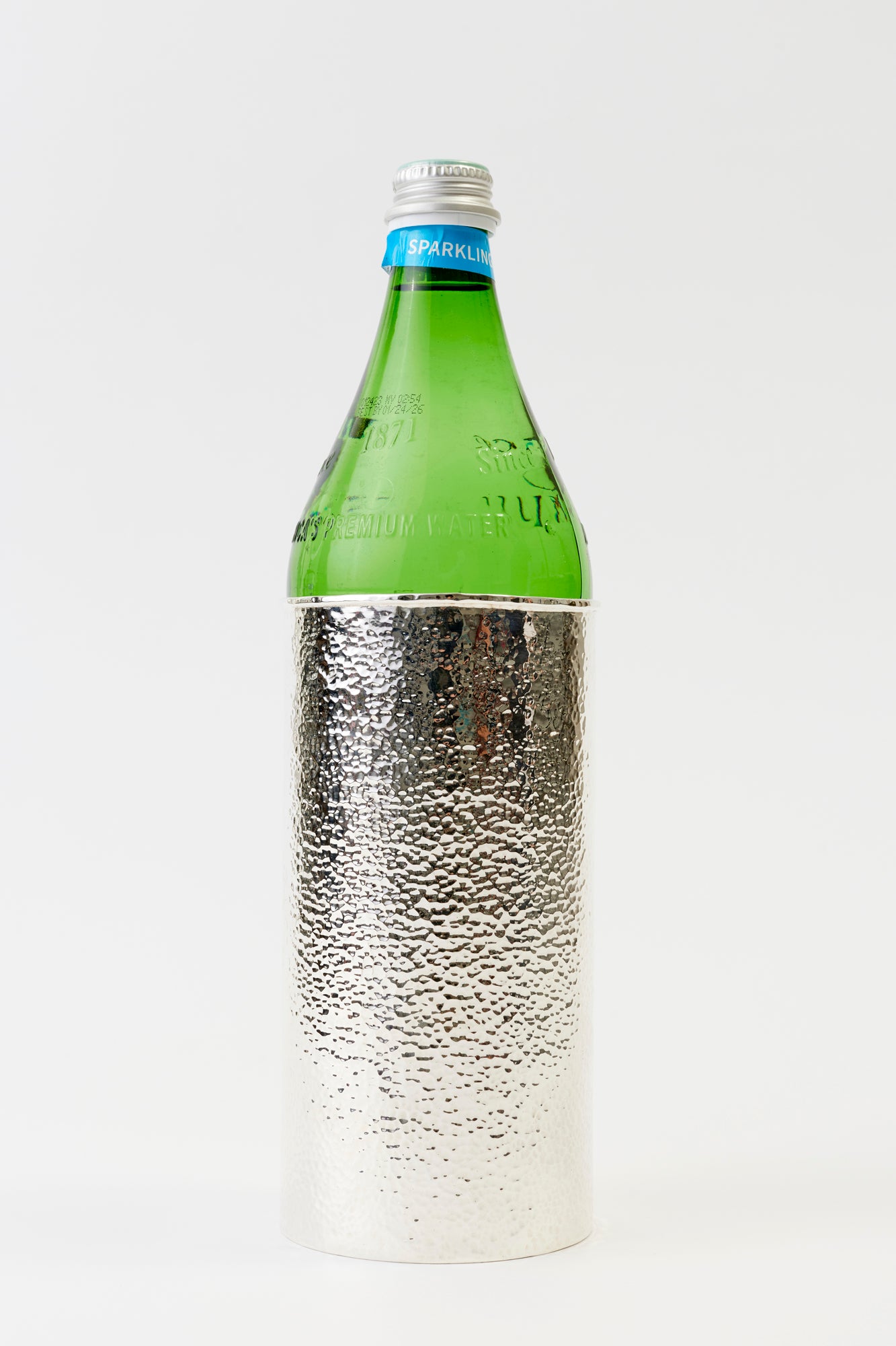 Hammered silver sleeve for bottles.