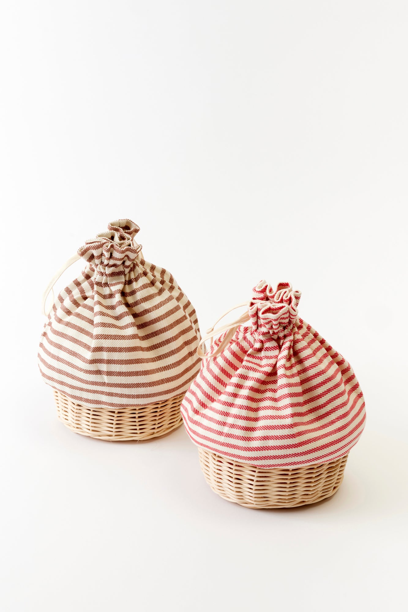 Stylish bread basket with a striped warmer, designed to keep bread fresh and warm. The basket features a classic woven design and is complemented by a soft, striped fabric warmer.