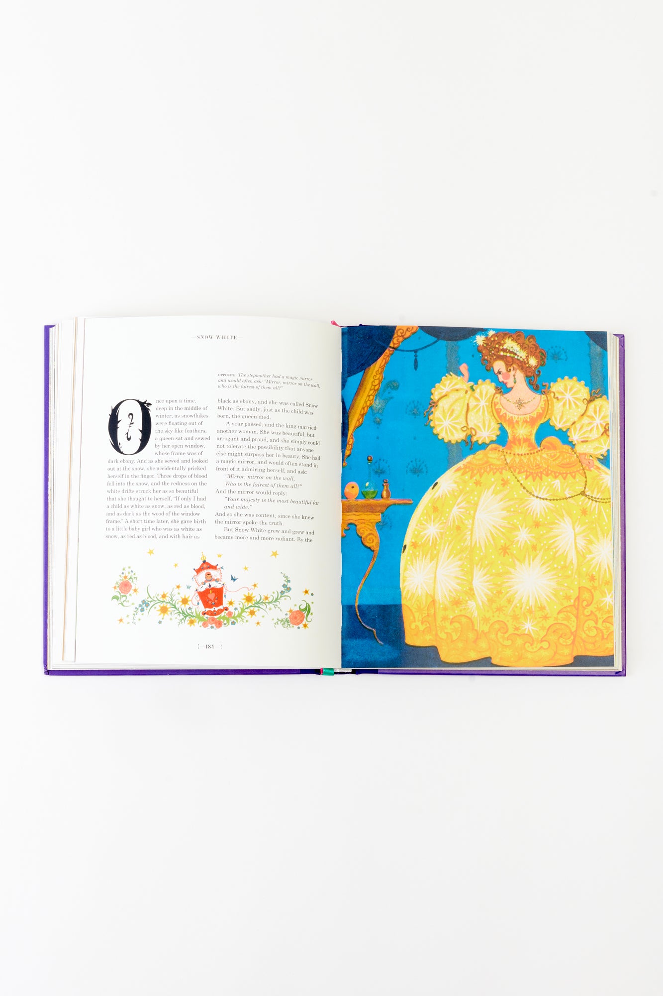 A beautifully illustrated page from The Fairy Tales of the Brothers Grimm, featuring the story of Snow White. Vibrant artwork of a regal figure in a golden gown complements the timeless text, making this edition a visual and literary delight.