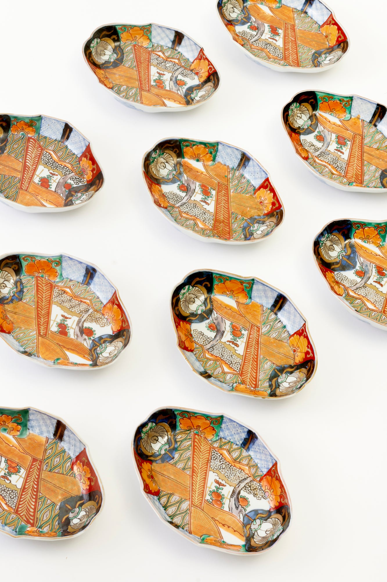 Set of 10 vintage Imari porcelain boats with intricate multi-colored patterns, featuring floral and geometric designs.