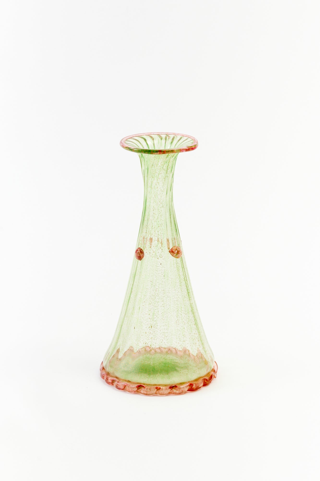 A green ribbed glass is accented by pink berries and a ruffled base.