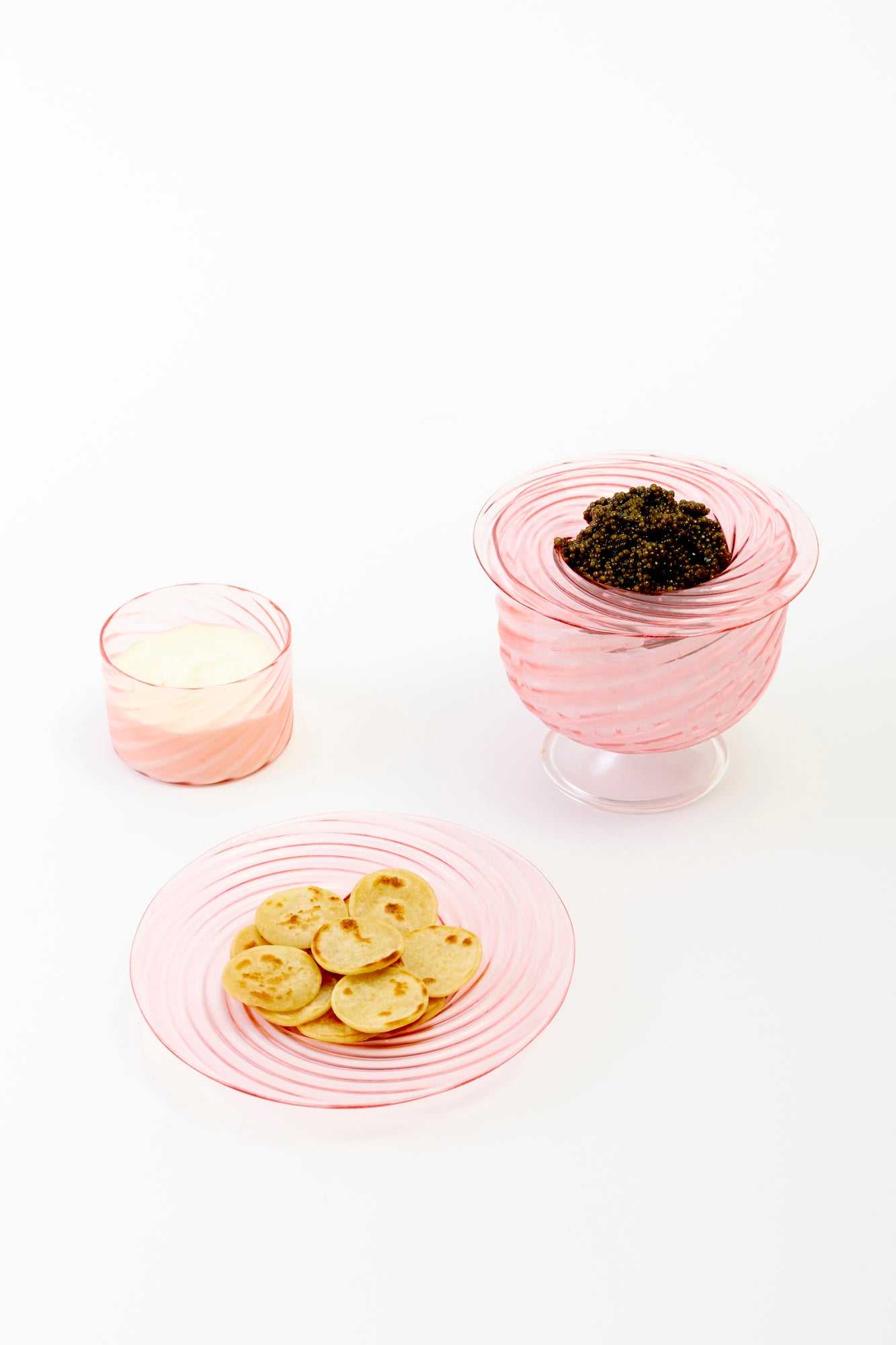 Handblown blush glass salad plate with matching ramekin and caviar service.