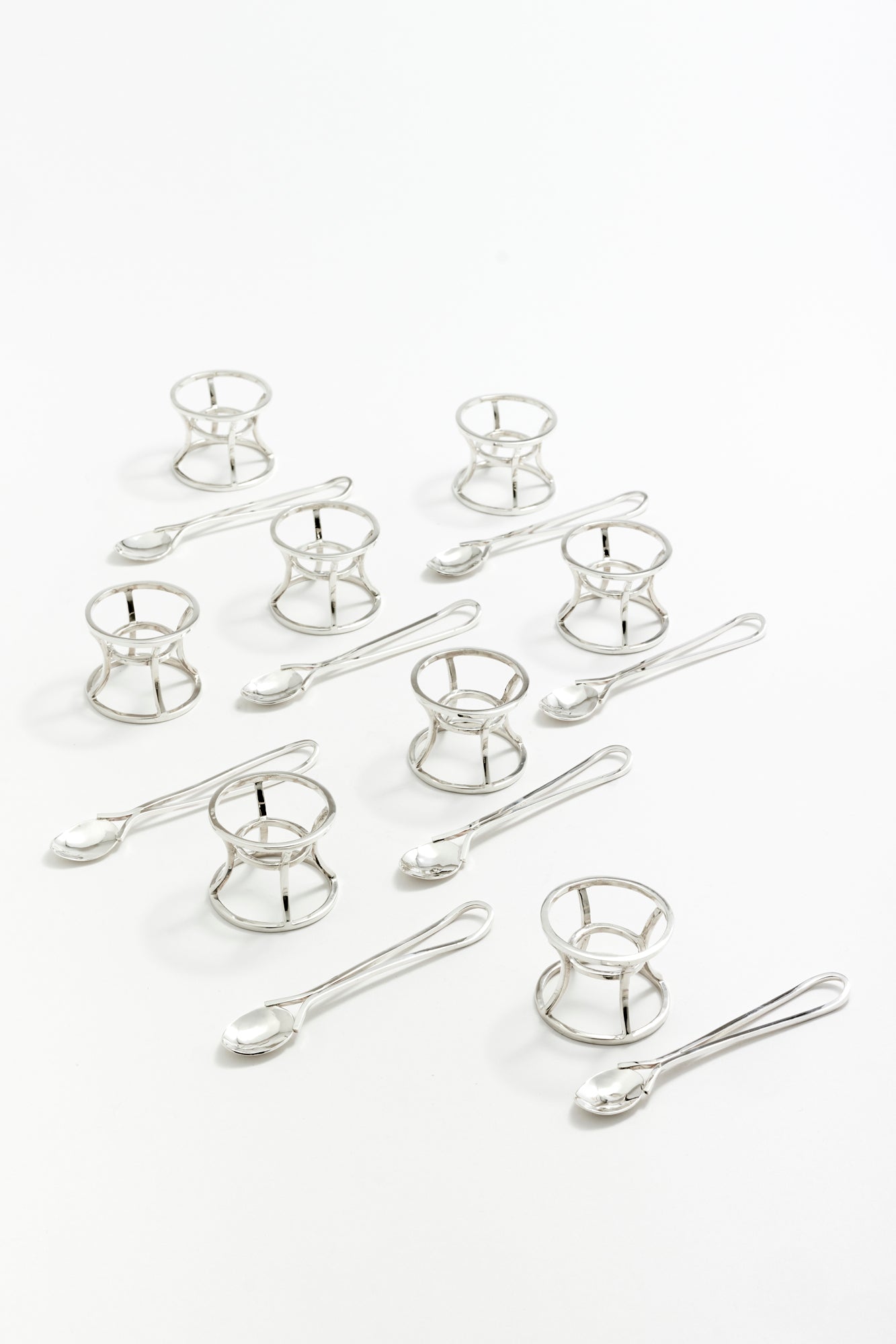 Architectural silver egg holders with matching spoons, offering an elevated breakfast presentation.