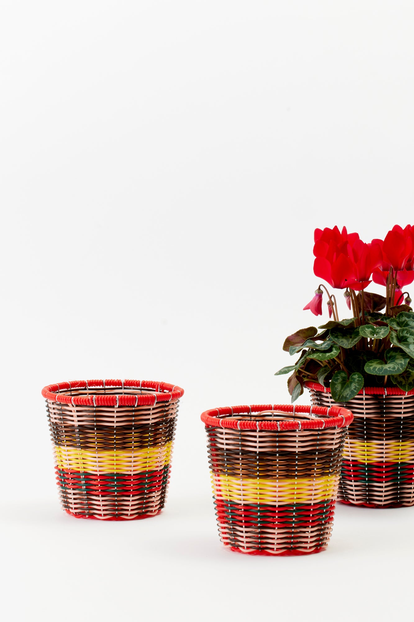 Woven Cachepot with red, pink, yellow, and brown weave. Perfect for plants.