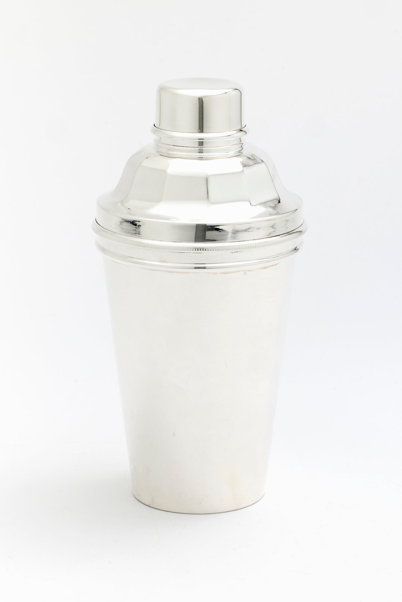 Vintage silver cocktail shaker with lemon juicer.