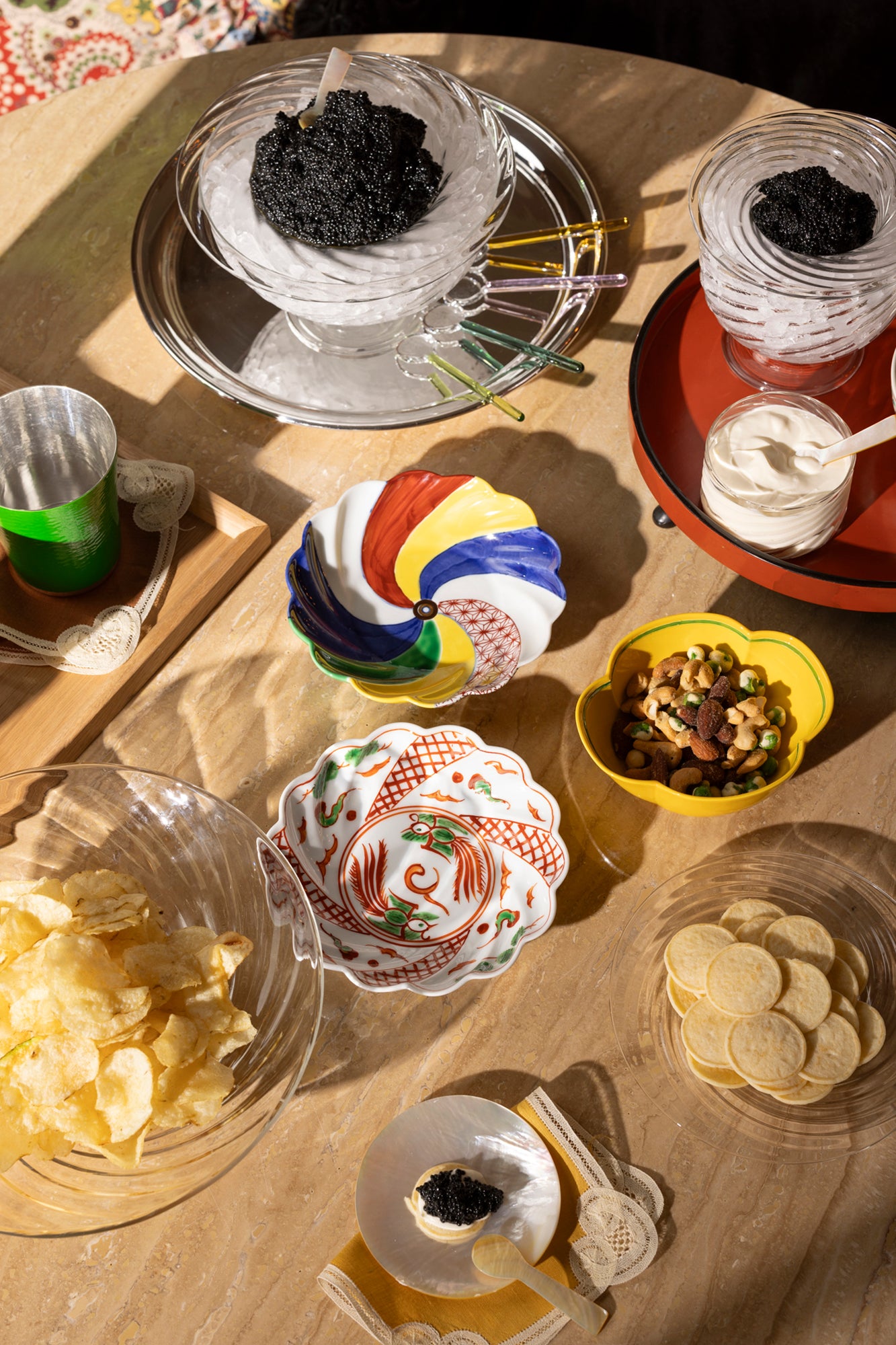 Photograph of table setting featuring caviar and mother of pearl plates and spoons. 