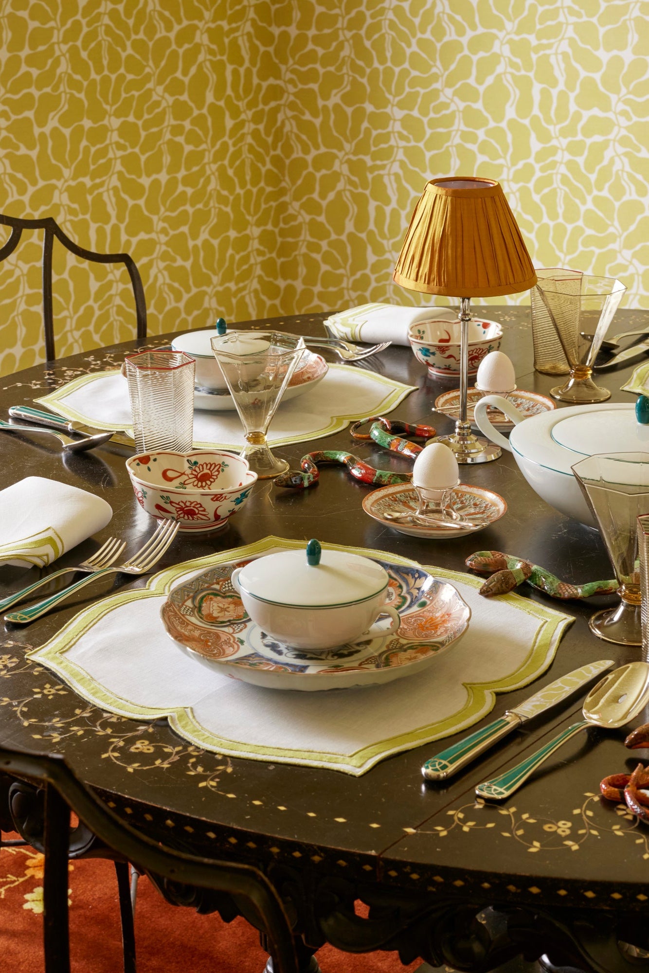 Table setting featuring variety of high end flatware, china, glassware, and linens. 