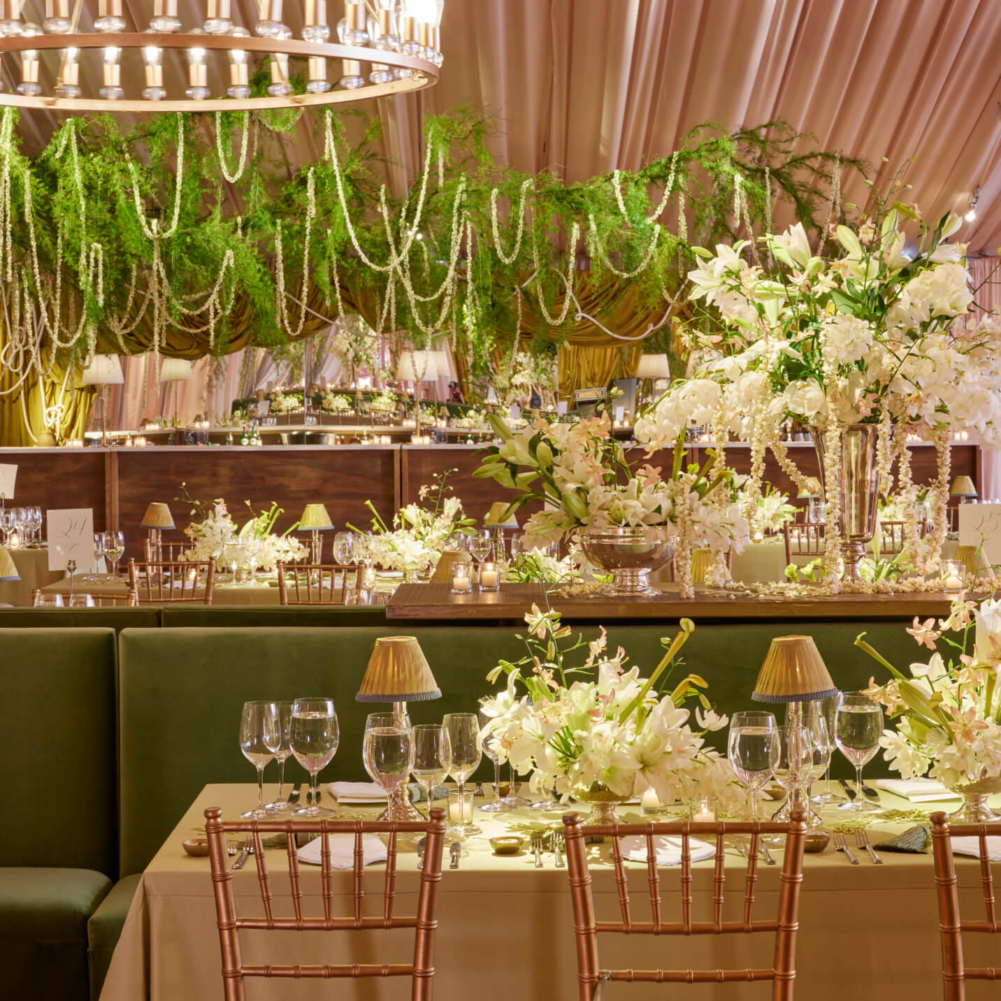 Decorative indoor setting with floral arrangements, table settings, and greenery.