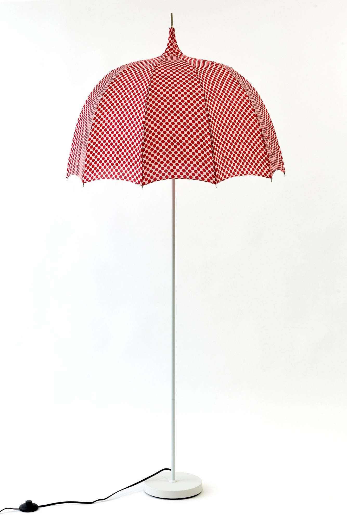 Red and white polka dotteed umbrella lamp on a white background