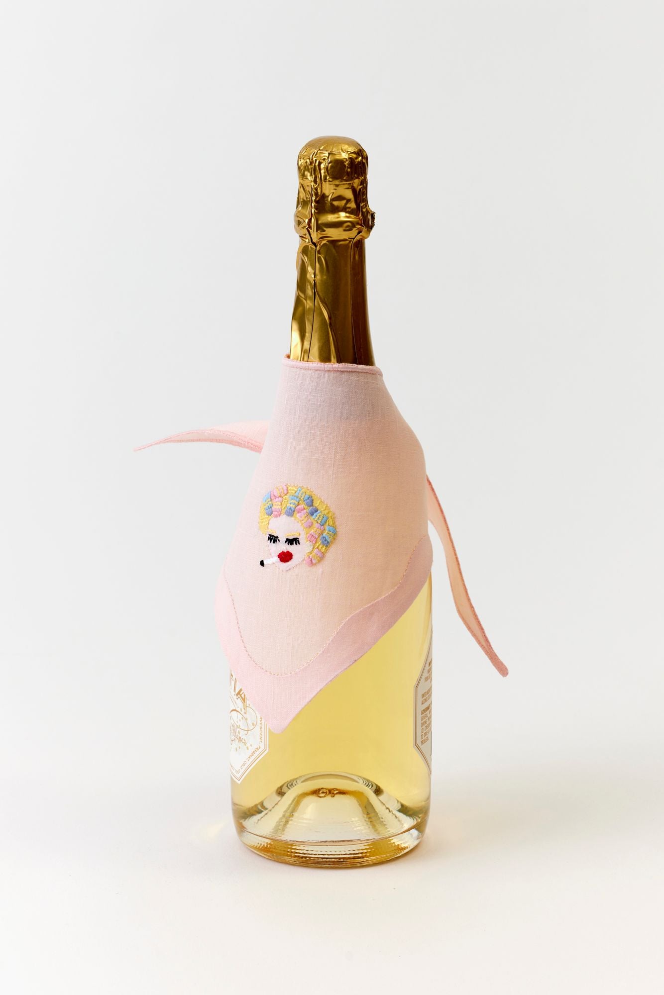 Bottle of champagne with a decorative pink bottle wrap on a white background