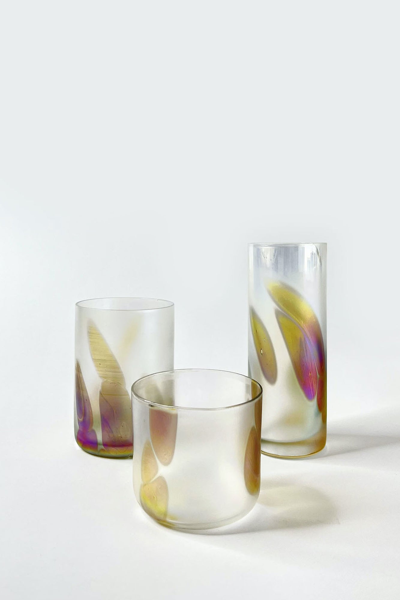 Iridescent glass tumblers with purple and golden marks, perfect for Collins, spritzes, or everyday use. 