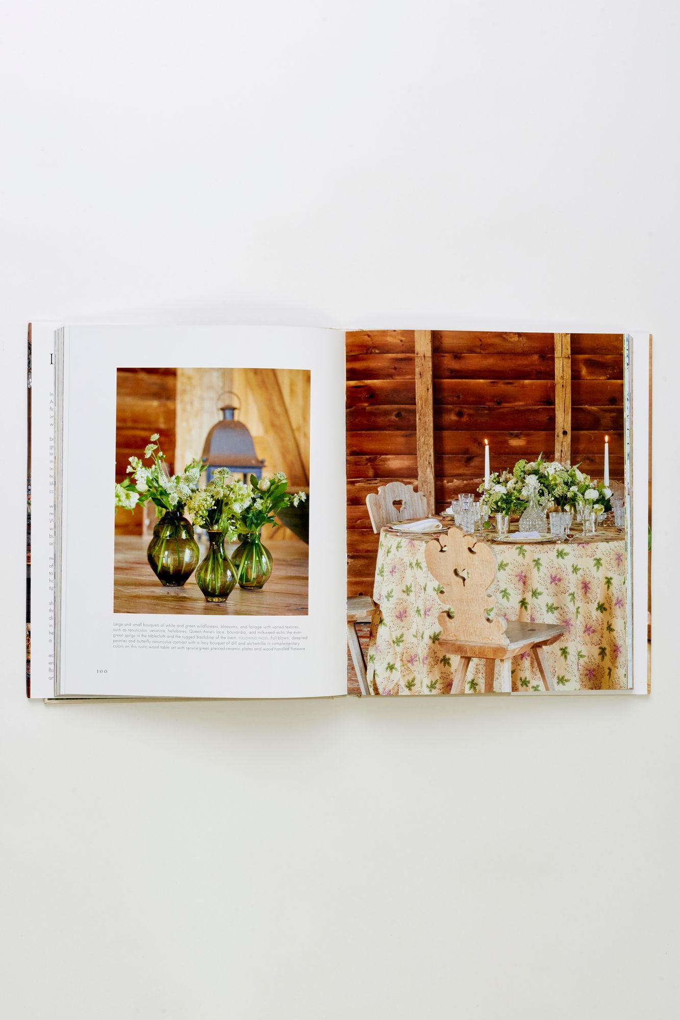 Book open to a page with two images: one of flowers in vases and another of a table setting with candles.