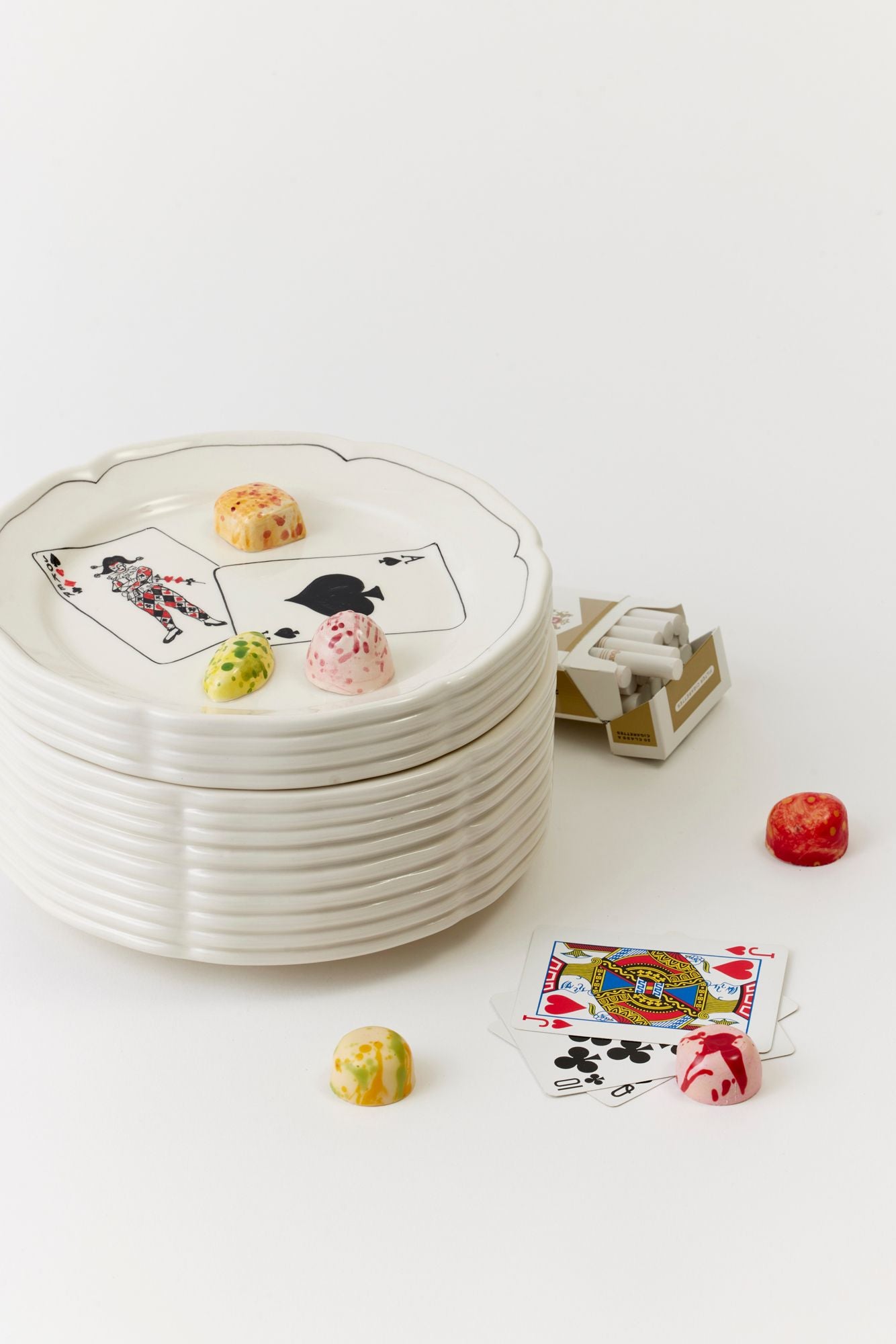 Trompe l'oeil ceramic box with decorative cards and candies on a white background