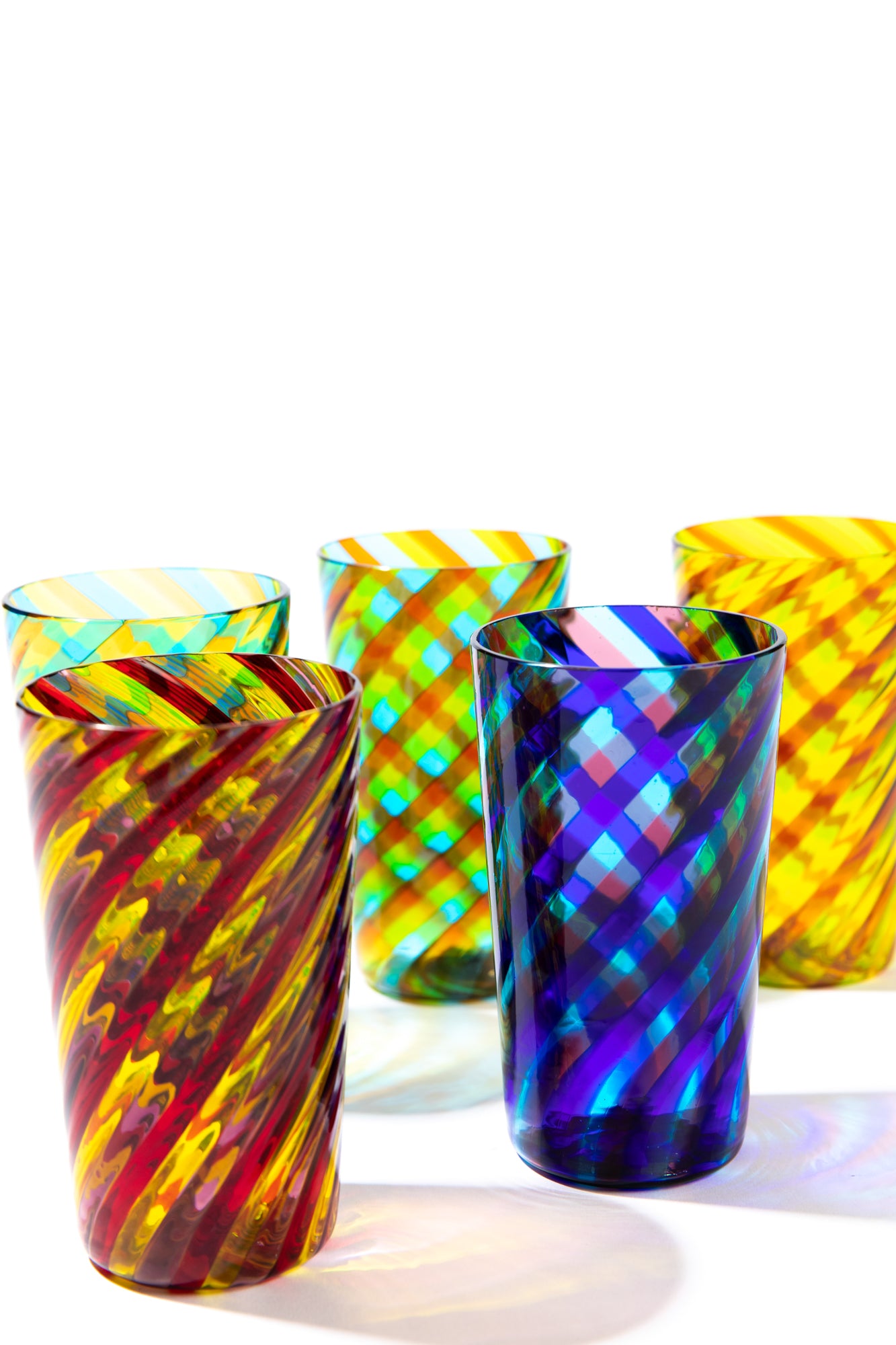 Collection of 5 tumblers in twisted and colorful Murano glass against a white background. 