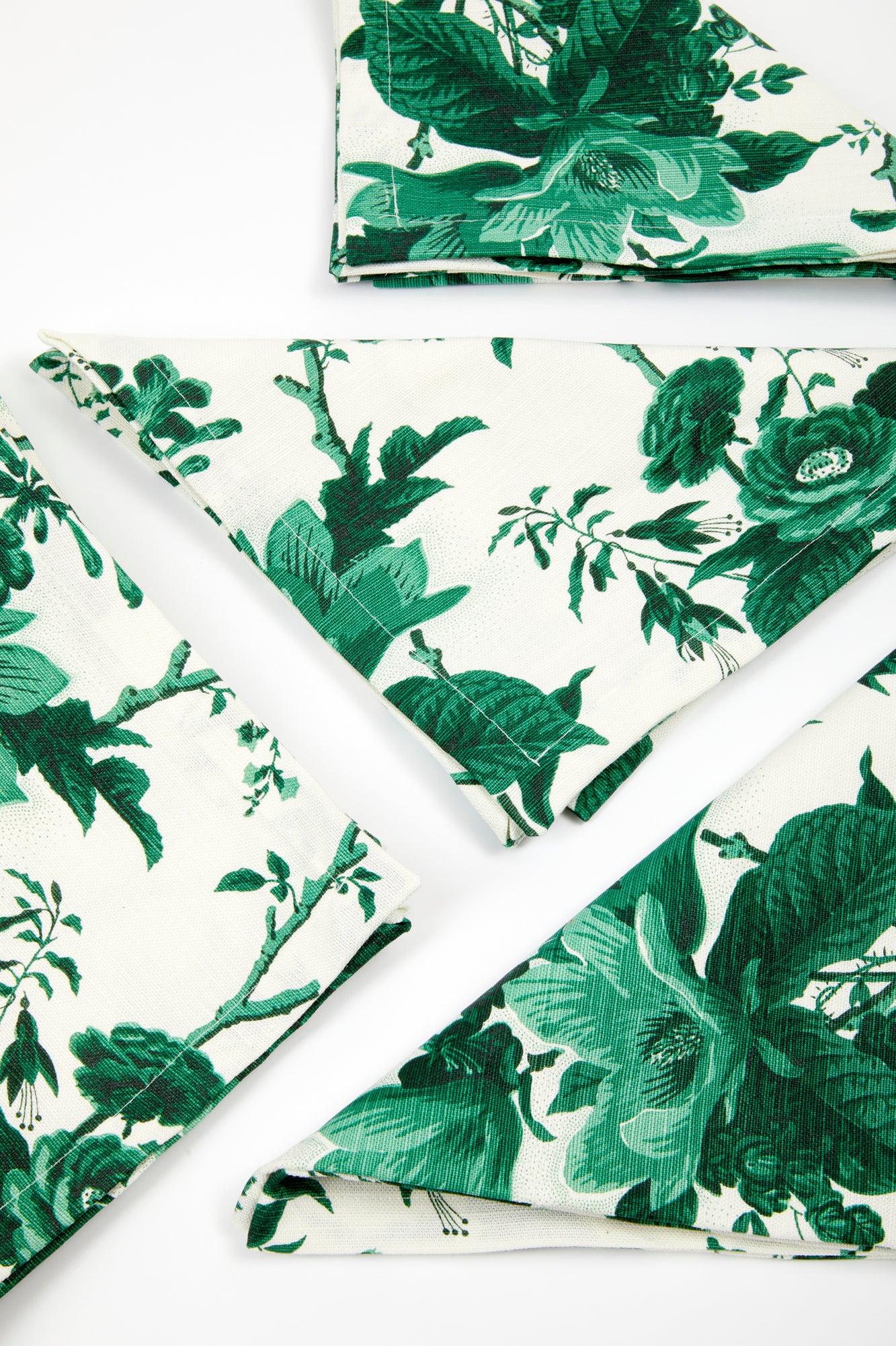 Set of dinner napkins in "De La Tour" floral Union Linen pattern, a green and white realistic floral print. 