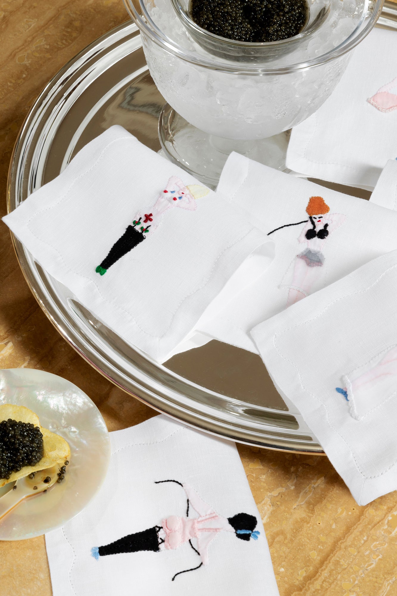 Embroidered cocktail napkins with scandalous women.