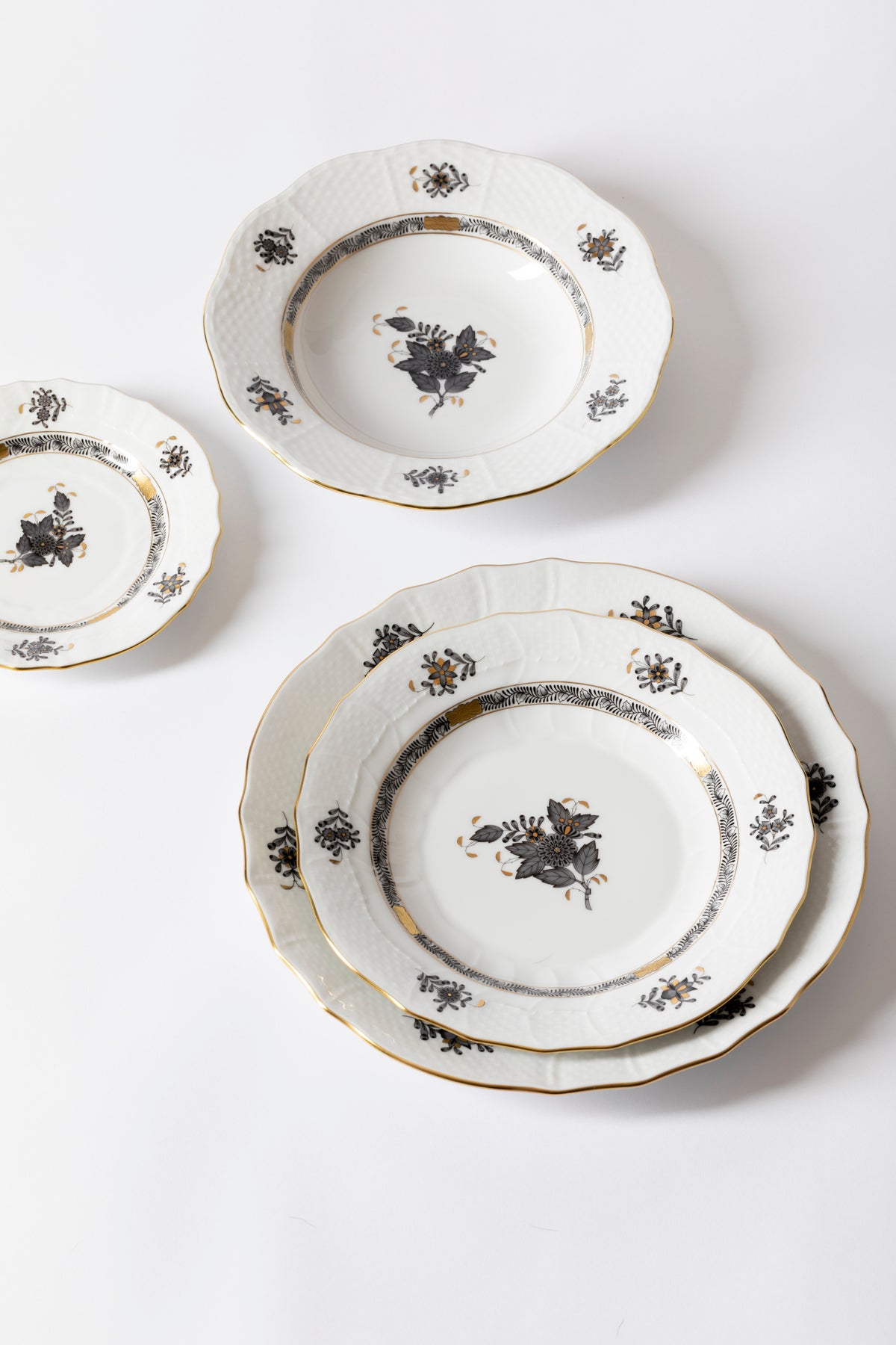 Five piece dinner service is hand painted on white porcelain including 24k accents. Black details.
