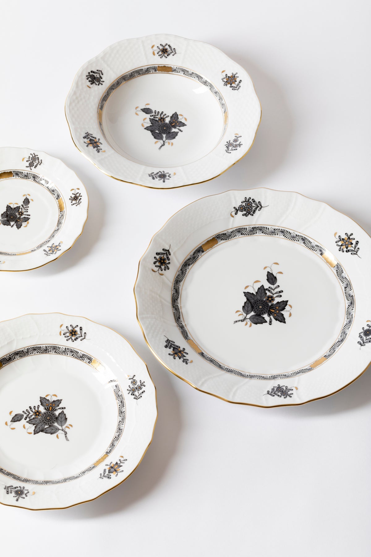 Five piece dinner service is hand painted on white porcelain including 24k accents. Black details.