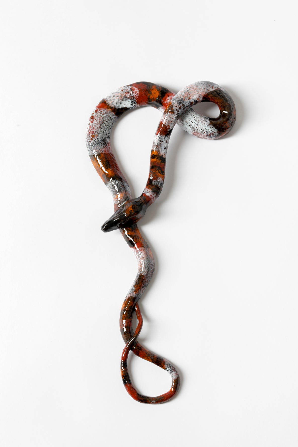 Ceramic snake glazed with red, black, and white. 