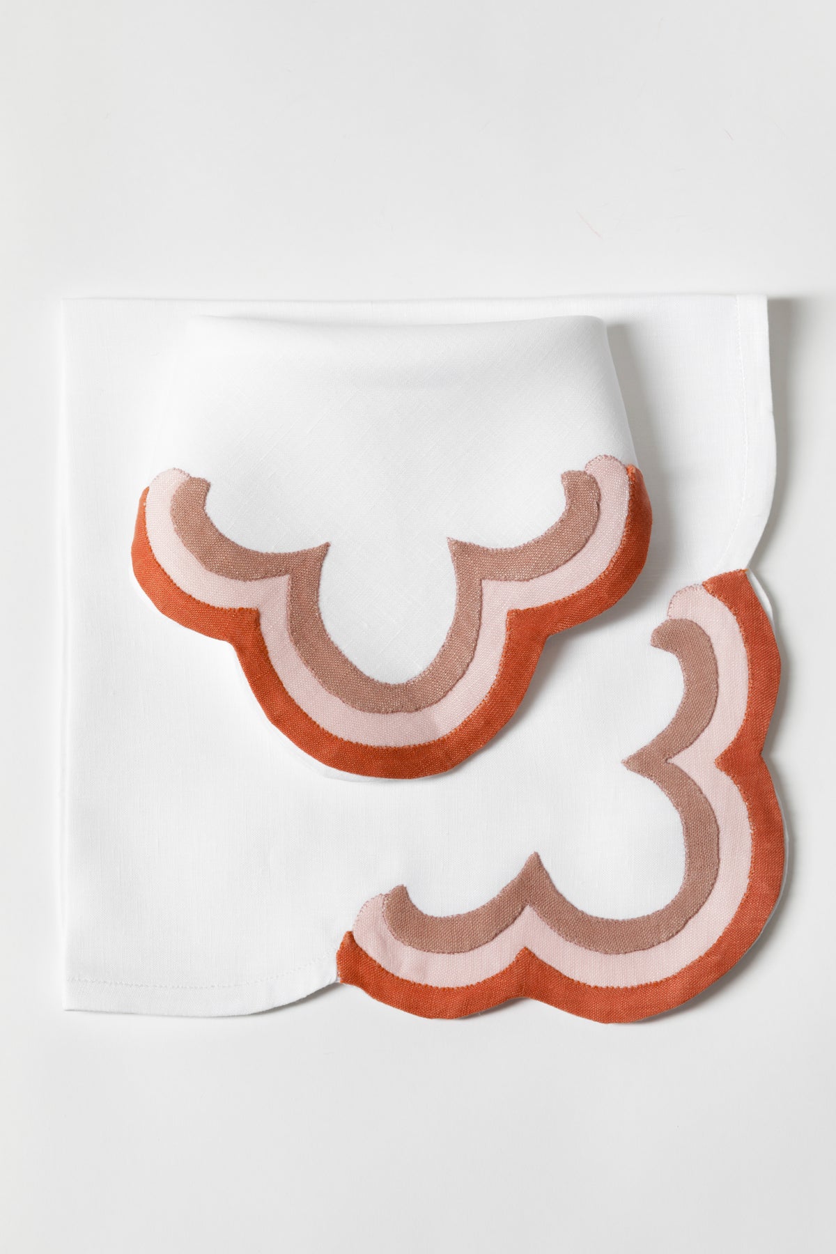 Linen dinner napkins in Persimmon with triple French stitch appliqué scallops made in Madeira, Portugal, exclusively for Houses & Parties.