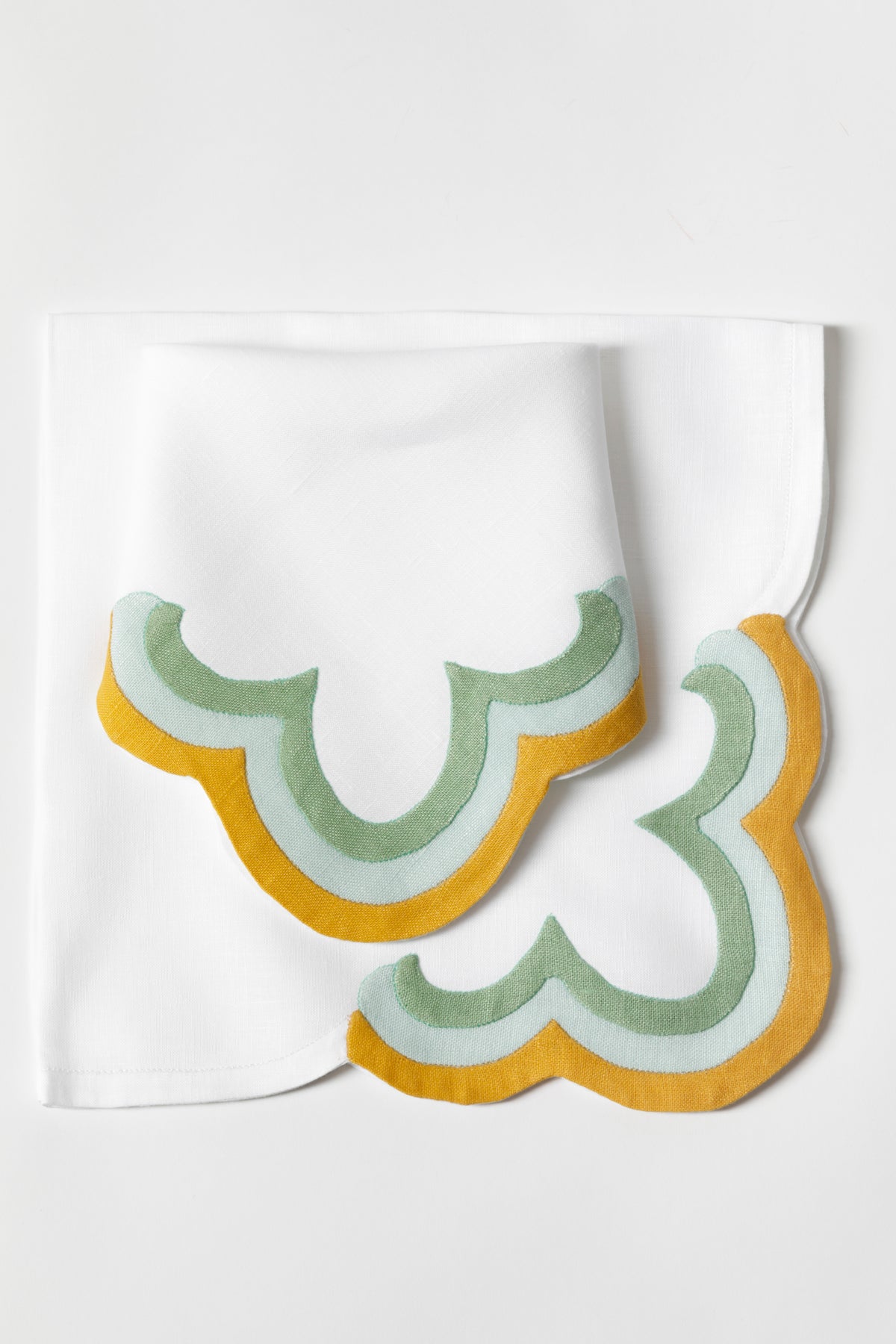 Linen dinner sized napkin with triple French stitch appliqué scallops made in Madeira, Portugal.